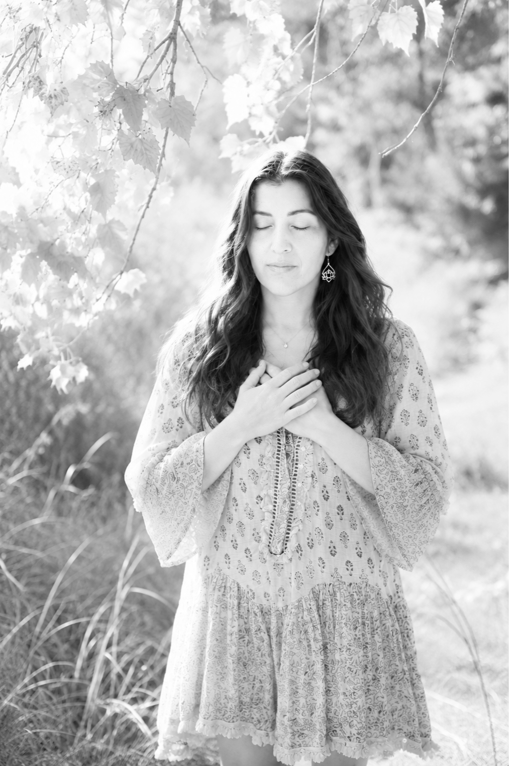 woman with hands on her heart listening in nature