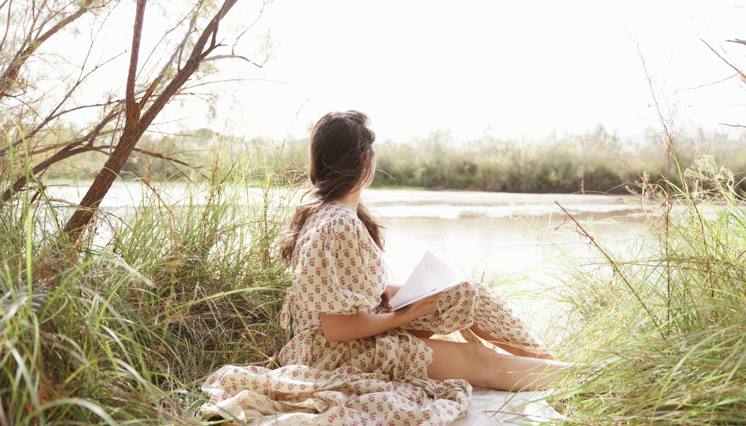 woman sitting in nature practicing grounding and reflection