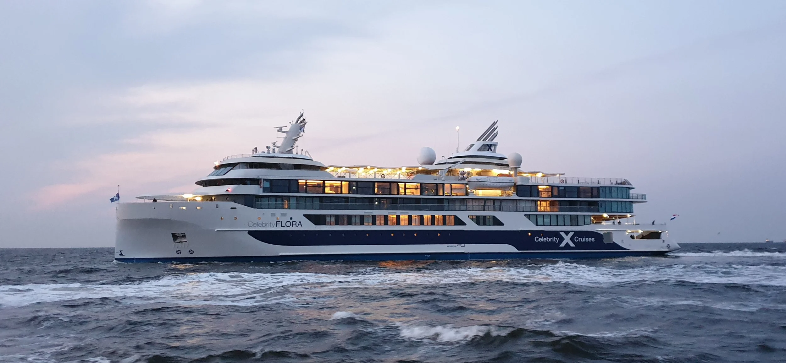 The Celebrity Flora, an all-suite luxury mega-yacht, sailing in the open ocean.