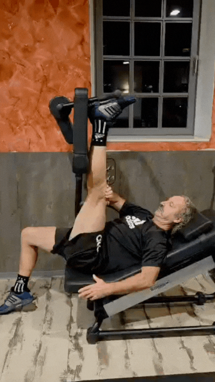 Mann beim Beintraining mit einer Fitnessmaschine im Fitnessstudio.