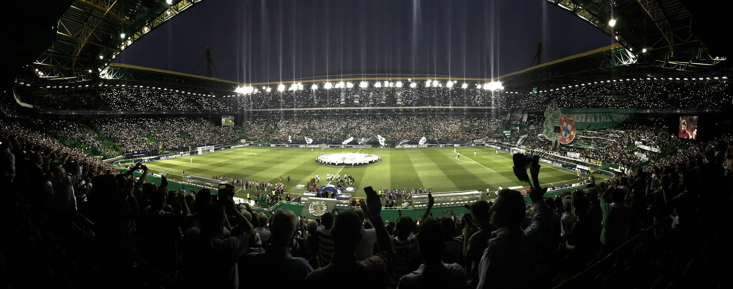 Vue panoramique du stade José Alvalade rempli de supporters du Sporting CP, avec un terrain de football avant un match de Ligue des champions.