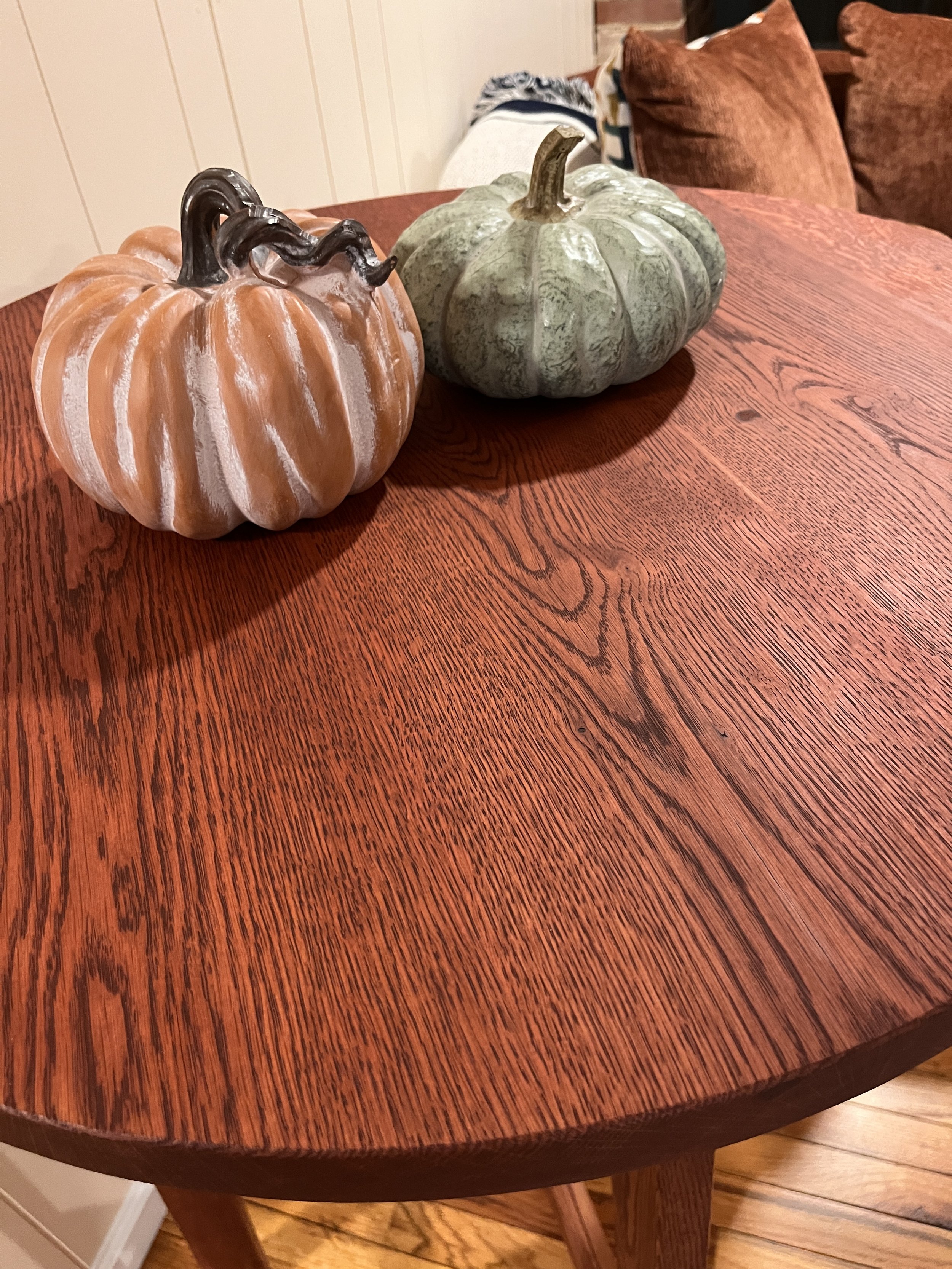Three decorative pumpkins on a wooden table.