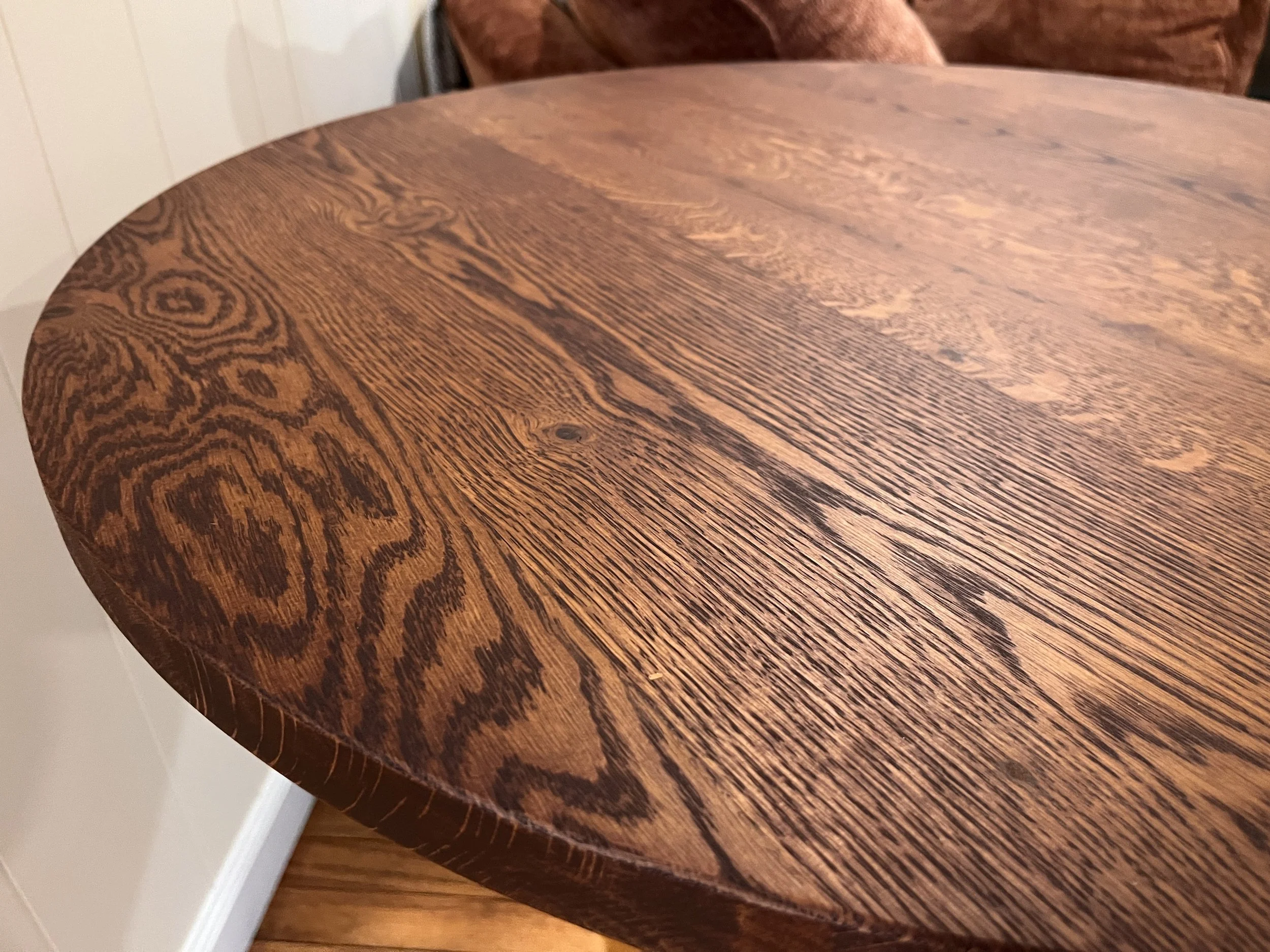 Close-up of a wooden table with a polished surface and visible wood grain.