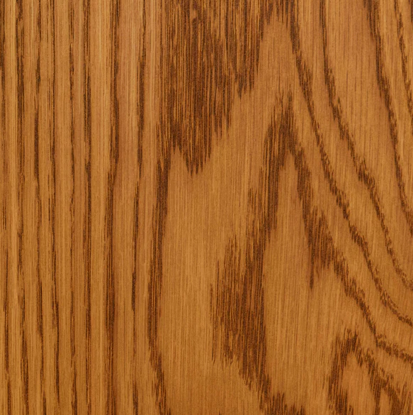Close-up of a wooden surface with visible grain patterns and a warm brown color.