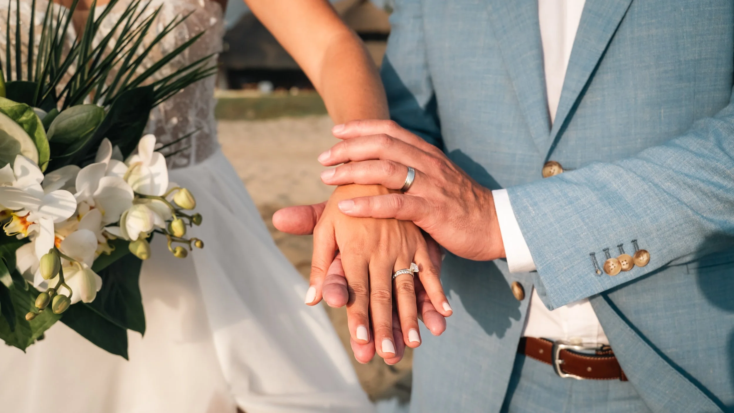 Emotional wedding photography at a luxury villa in Puerto Escondido, created for a US couple seeking an authentic destination experience in Mexico. Maried couple holding hands with their wedding rings during sunset.