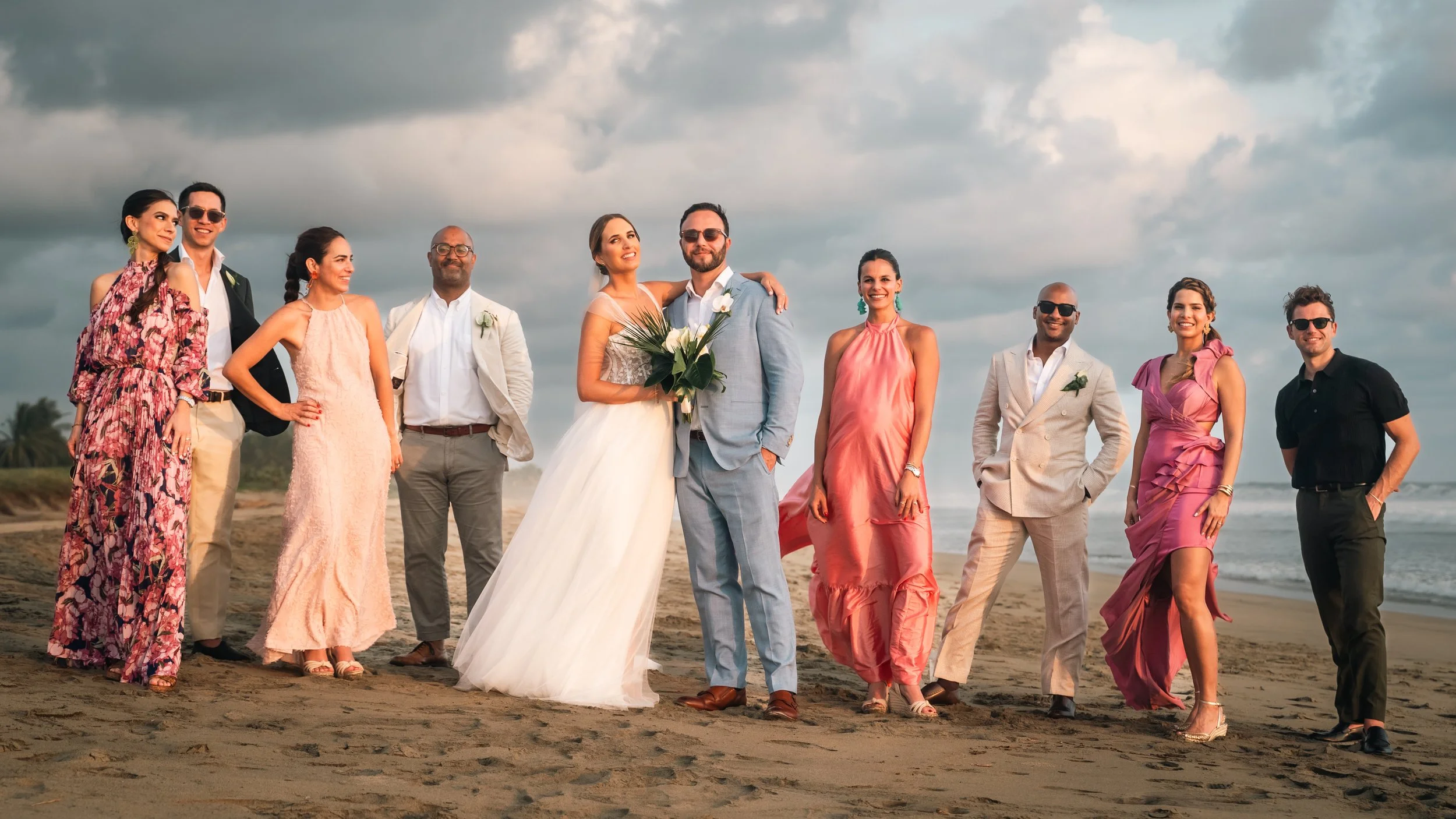 Sunset beach wedding in Puerto Escondido, Oaxaca, photographed with a documentary and high-end storytelling style. Groom and bride with their friends posing after the ceremony for the wedding photoshoot.