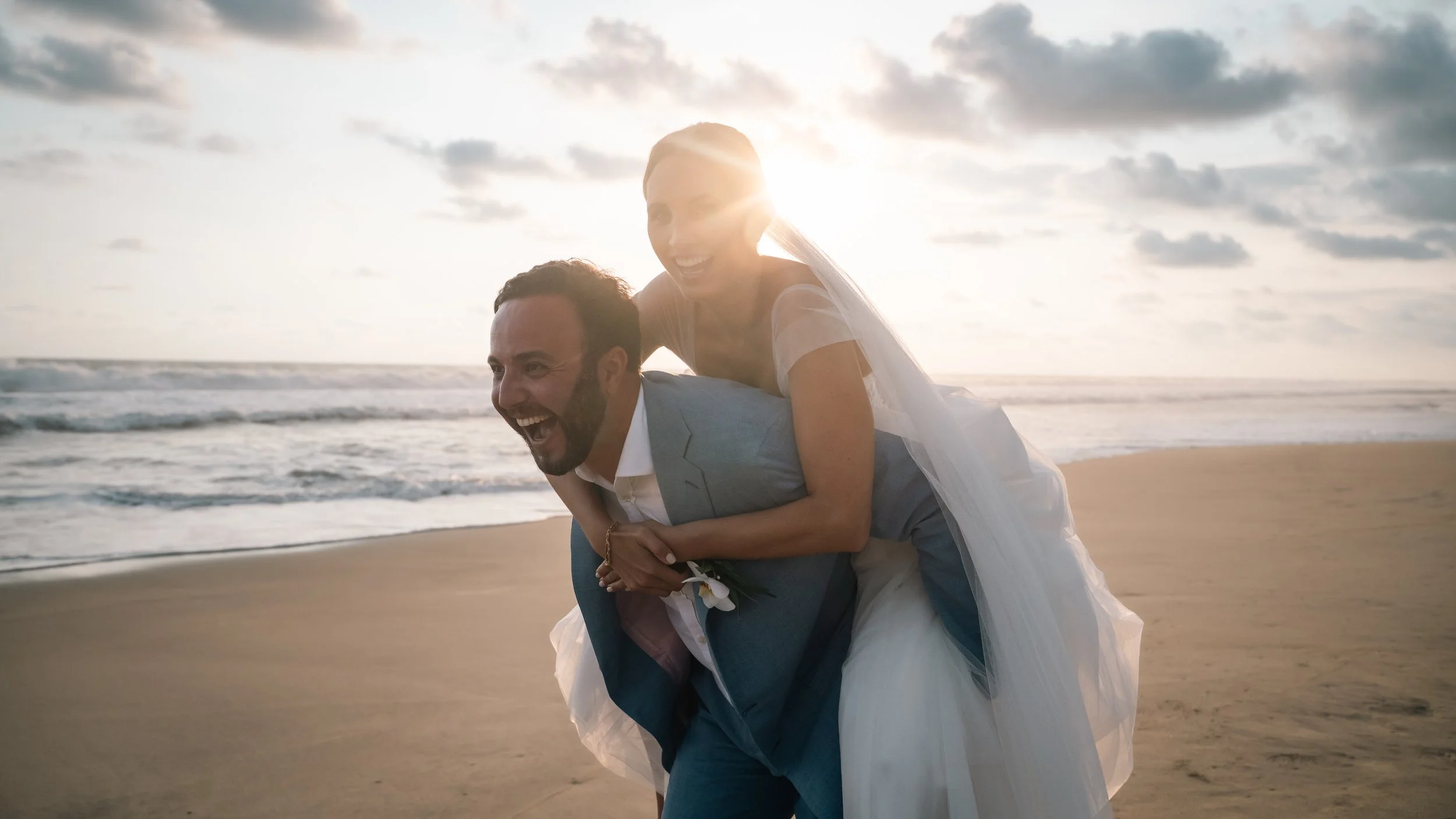 Emotional wedding photography at a luxury villa in Puerto Escondido, created for a US couple seeking an authentic destination experience in Mexico. Maried couple running and smiling during sunset.