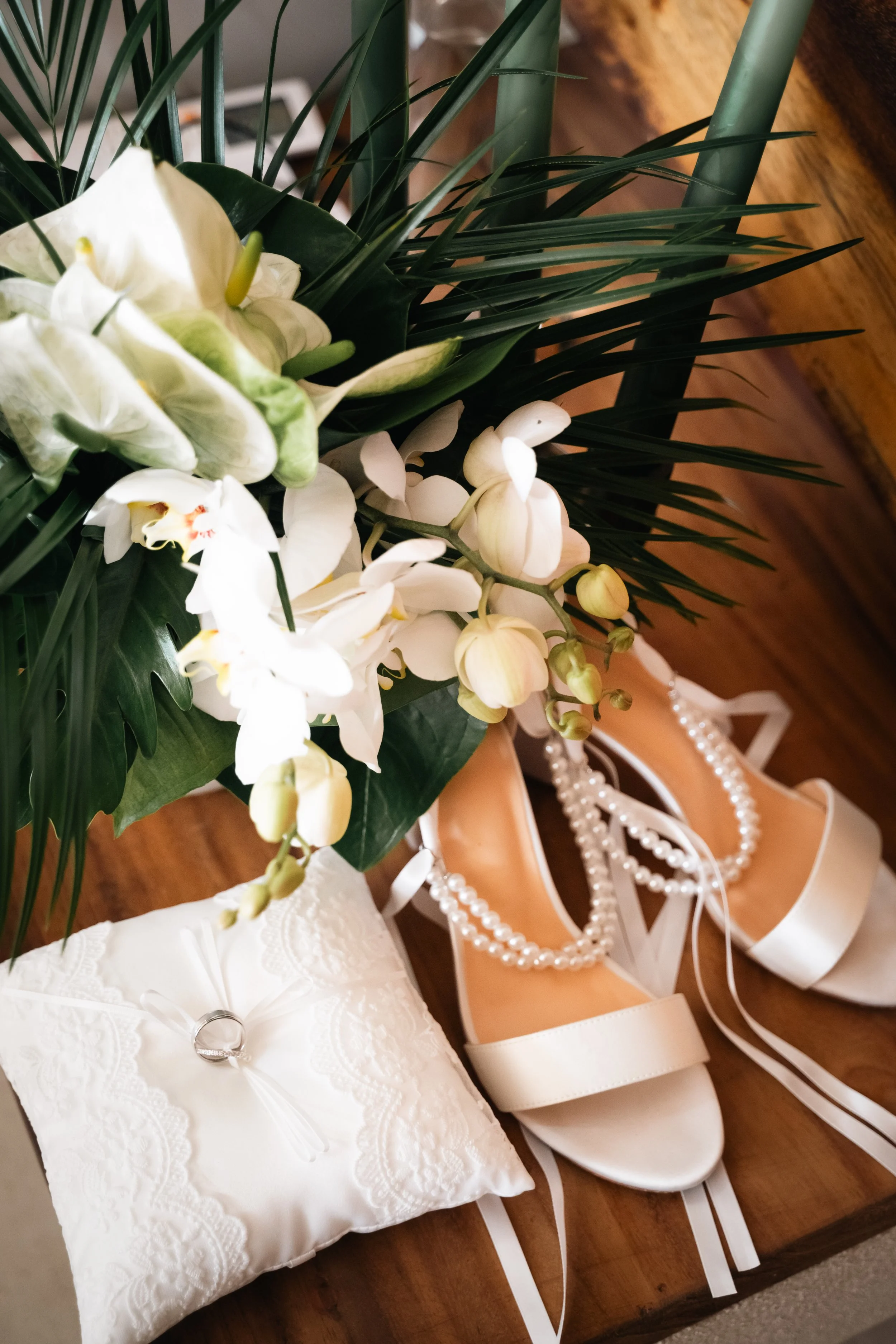 Destination wedding at a luxury villa in Puerto Escondido, photographed with a natural, emotion-driven approach for a couple from the United States. Photography of floral composition with the rings and shoes of the bride.
