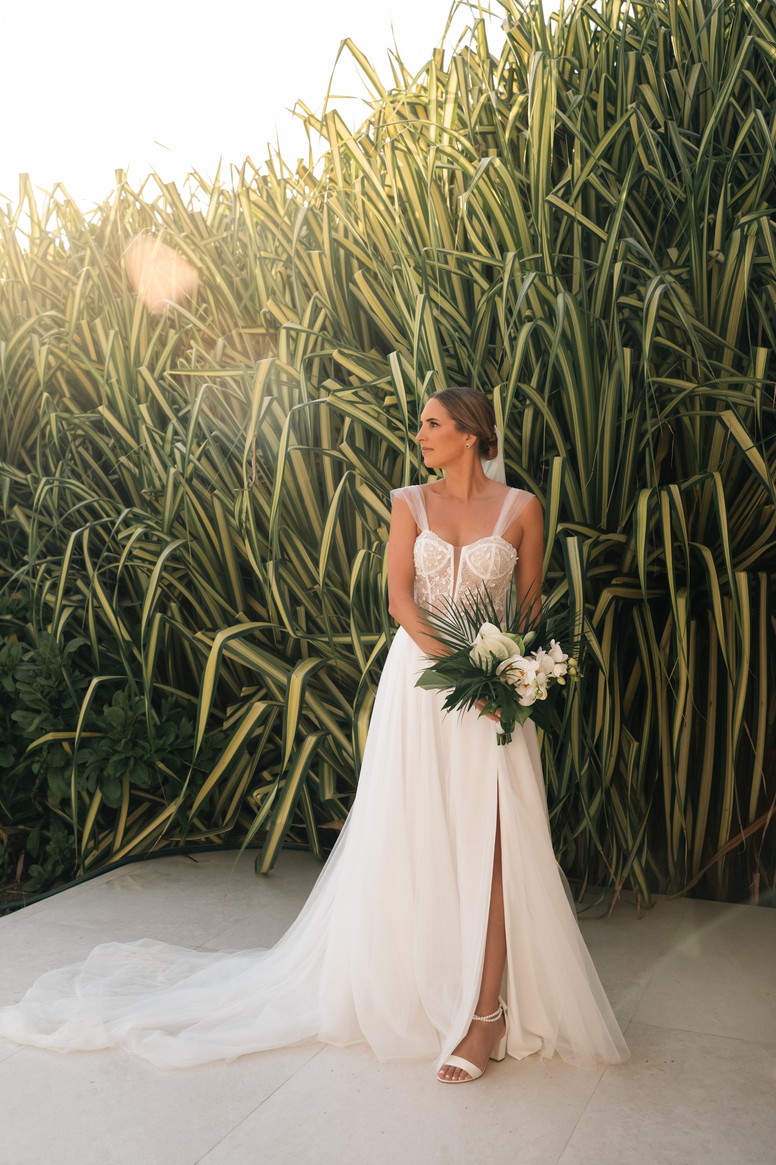 High-end destination wedding photography in Puerto Escondido, blending natural light, emotion, and refined elegance. Bride in her dress and floral composition before the ceremony.