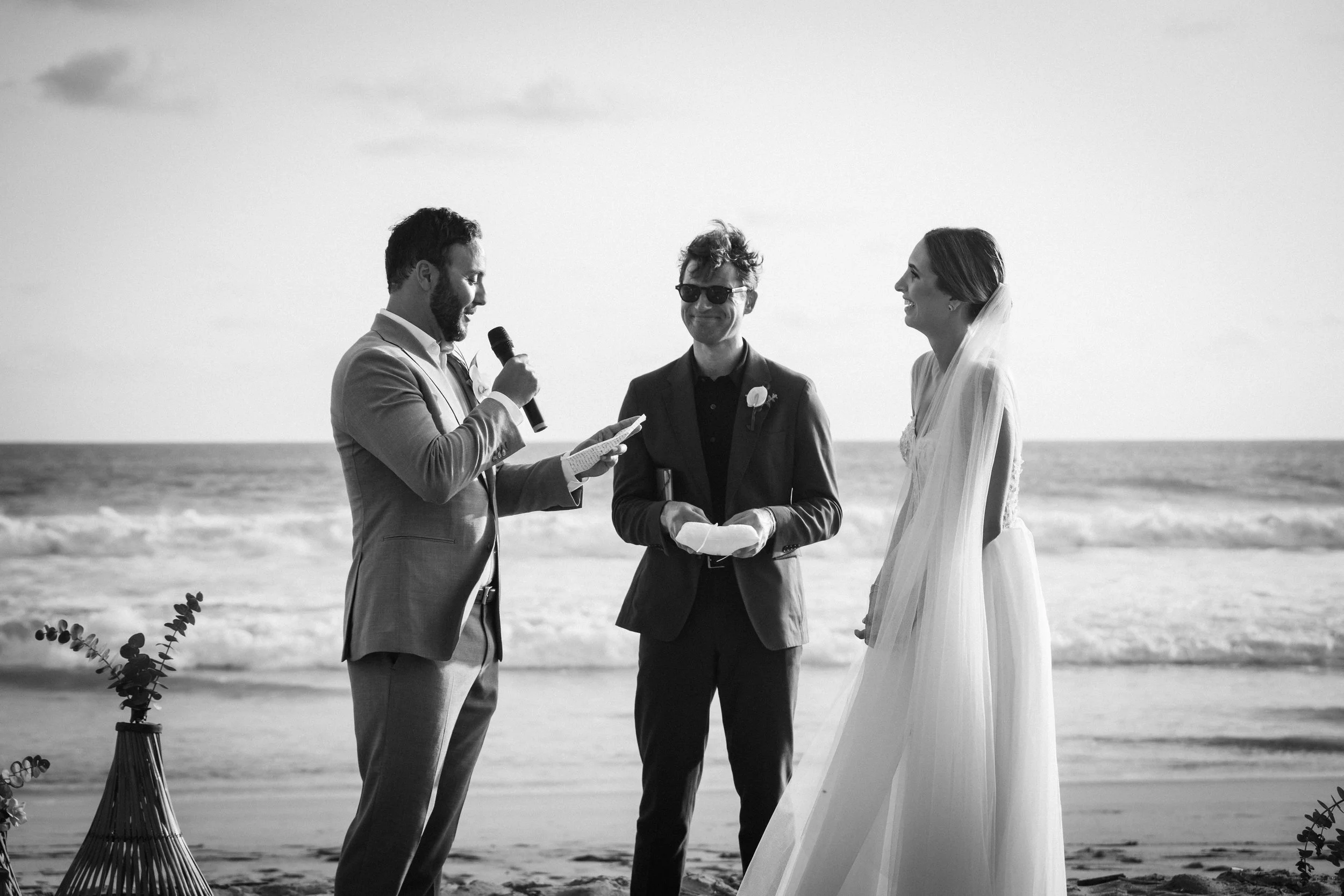 Black and White wedding photography during a destination wedding in Puerto Escondido, captured at a private luxury villa for an American couple. Sharing vows during the ceremony of a maried couple.