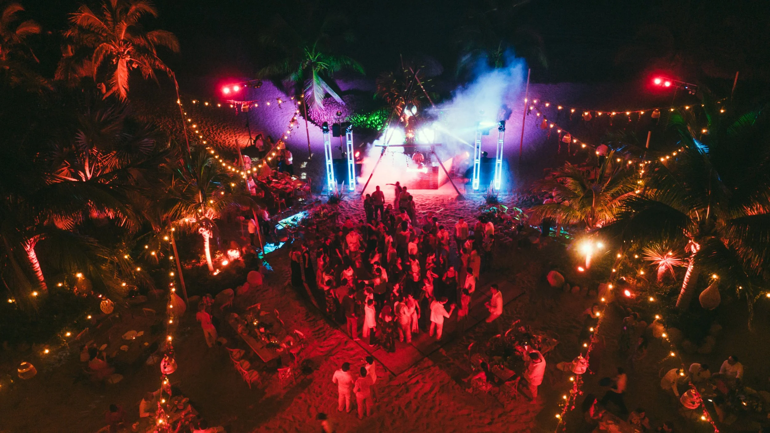 Maried couple dancing in their wedding party in the middle of the dancing floor with all their guest around them. Very happy vibes and colorfull. nice light beam in luxurious Villa in Puerto Escondido