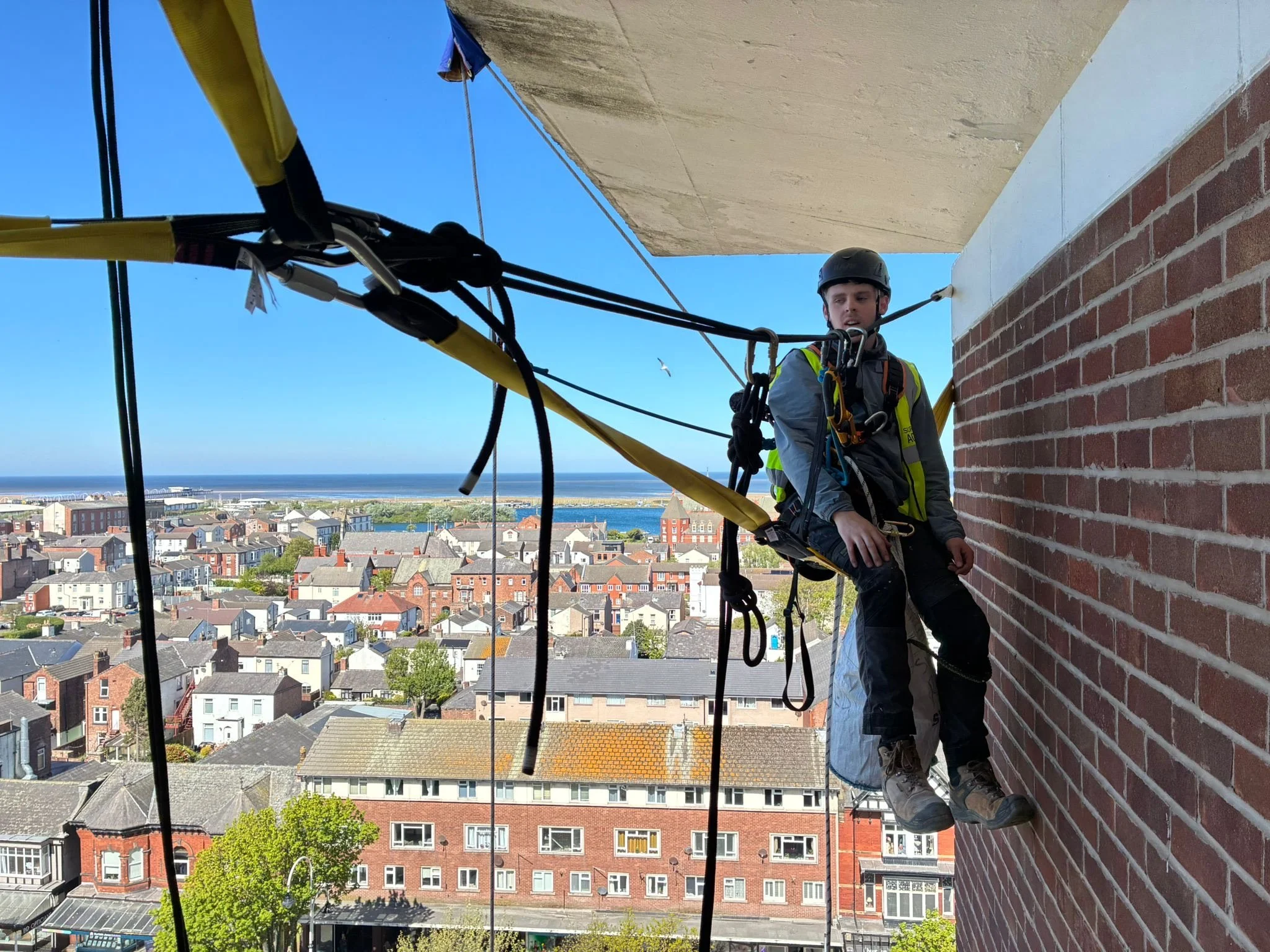 Rope Access conducting maintenance on a block apartment building.