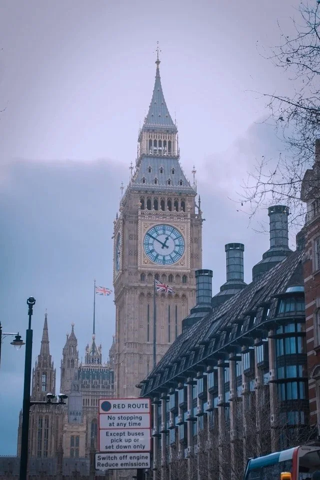 Big Ben clock tower with Union Jack flags in London, England.
