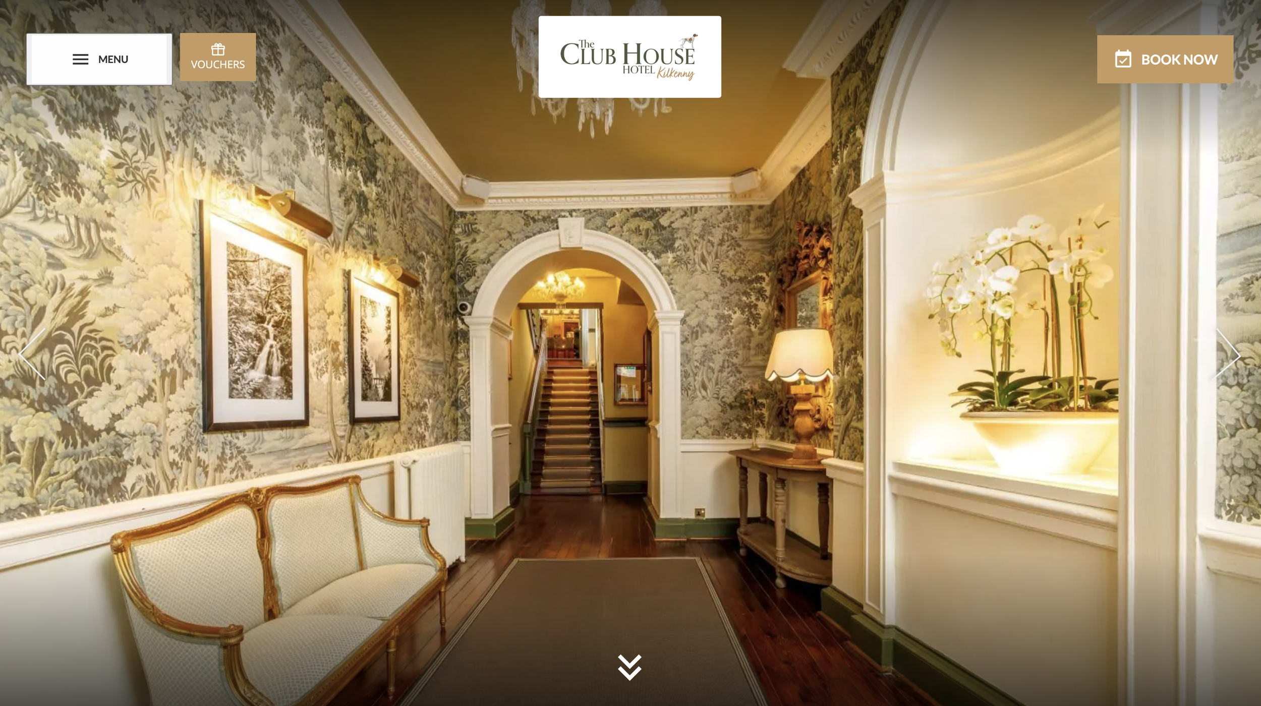 Beautiful, ornate and bright entrance lobby featuring an antique chair and historic staircase.