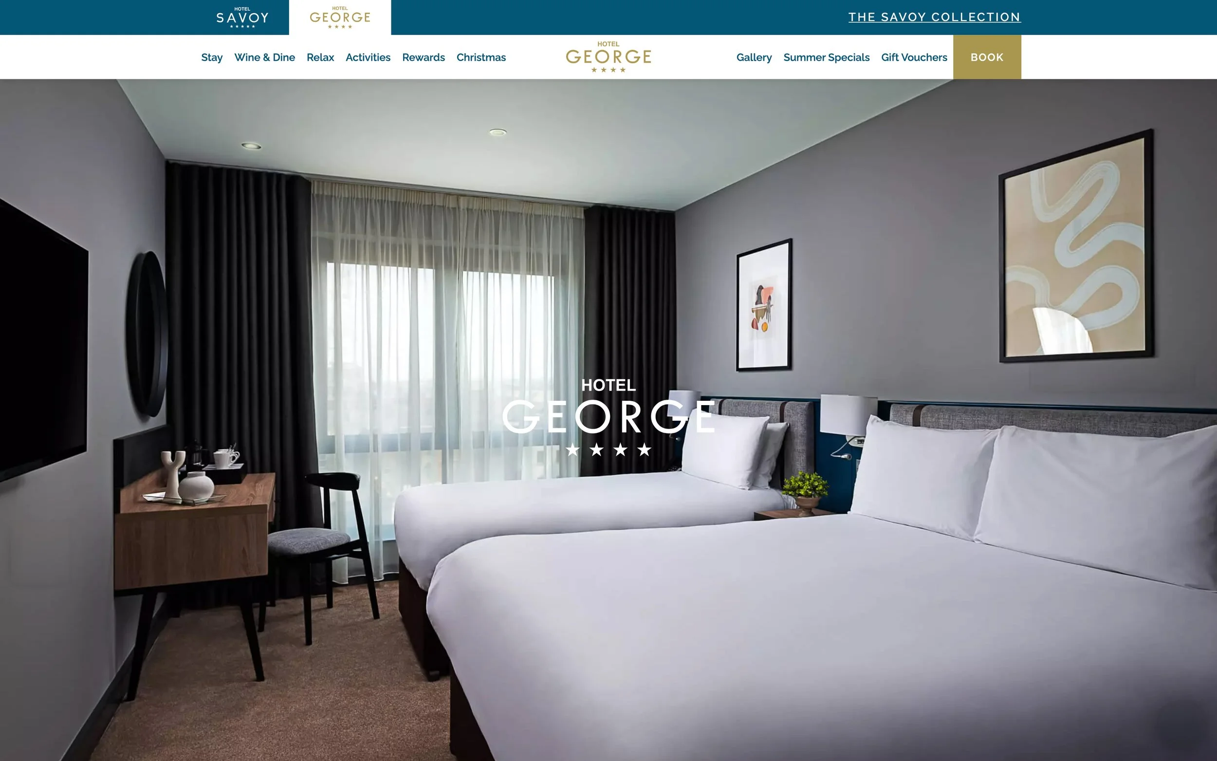 Spacious twin room with a large double bed next to a single bed, both draped in crisp white linen.