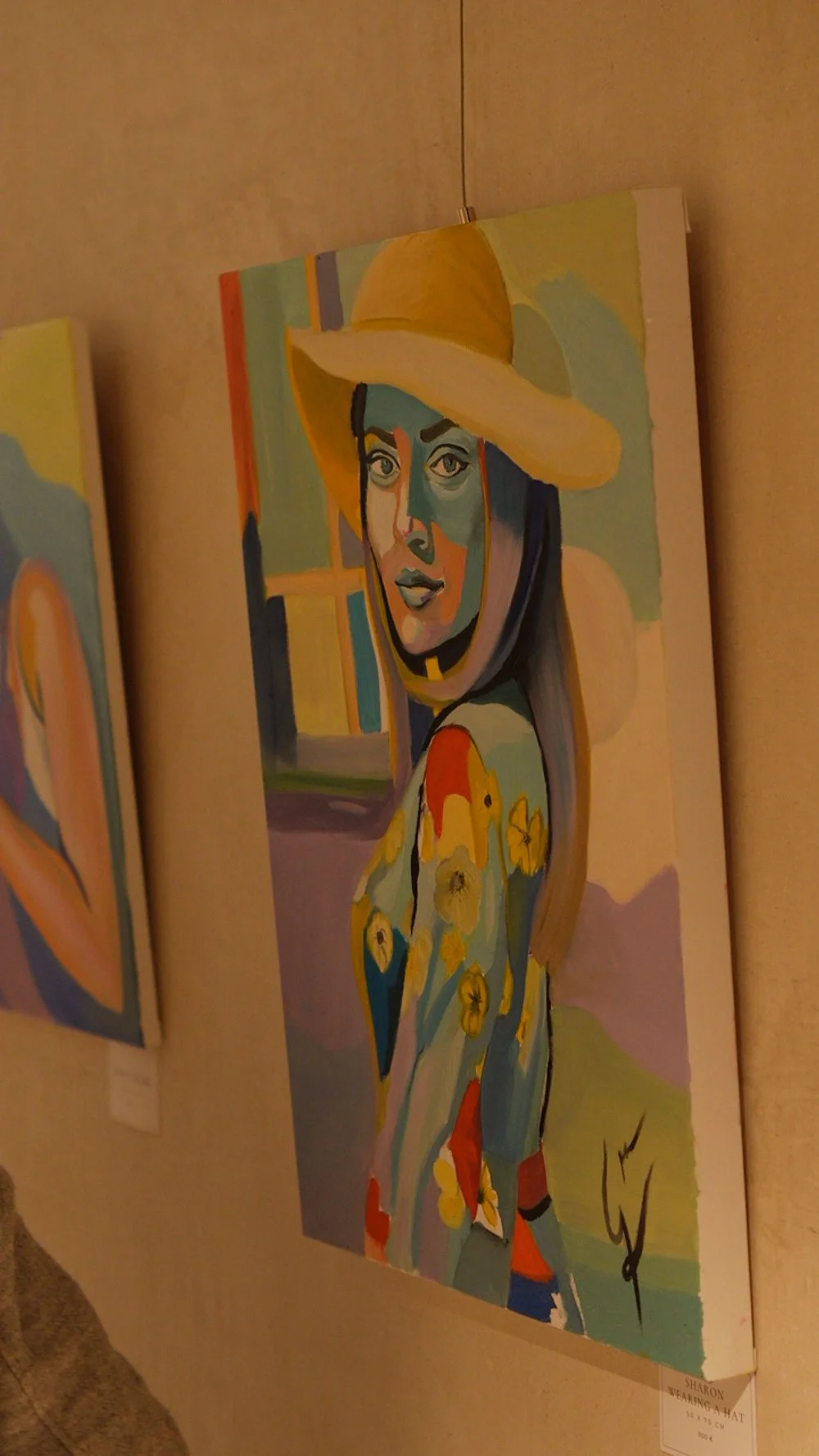 Retrato en estilo cubista de una mujer con sombrero amarillo y vestido con flores, en una galería de arte.