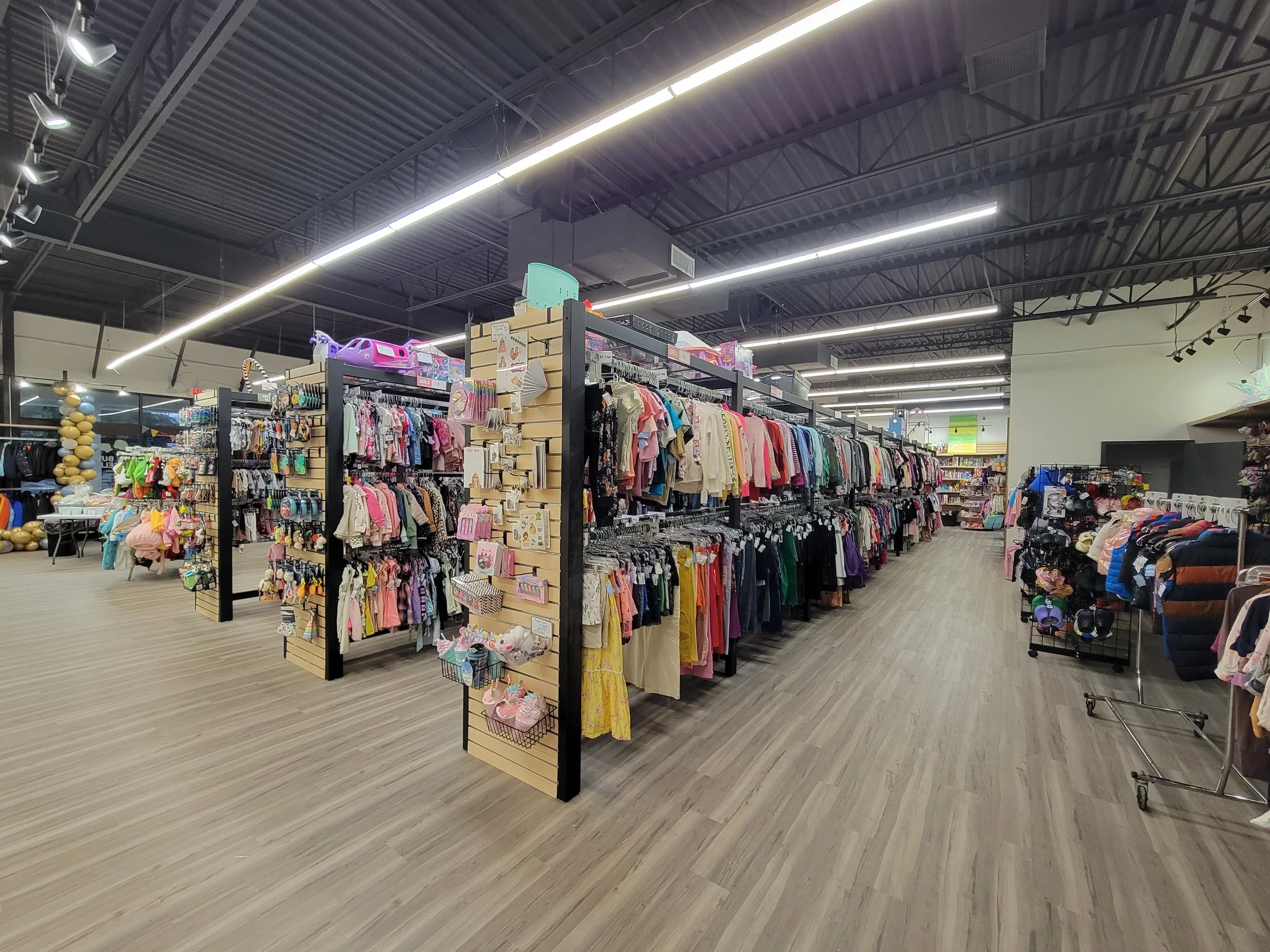 Retail space with children's items on shelving, LED bar lights overhead