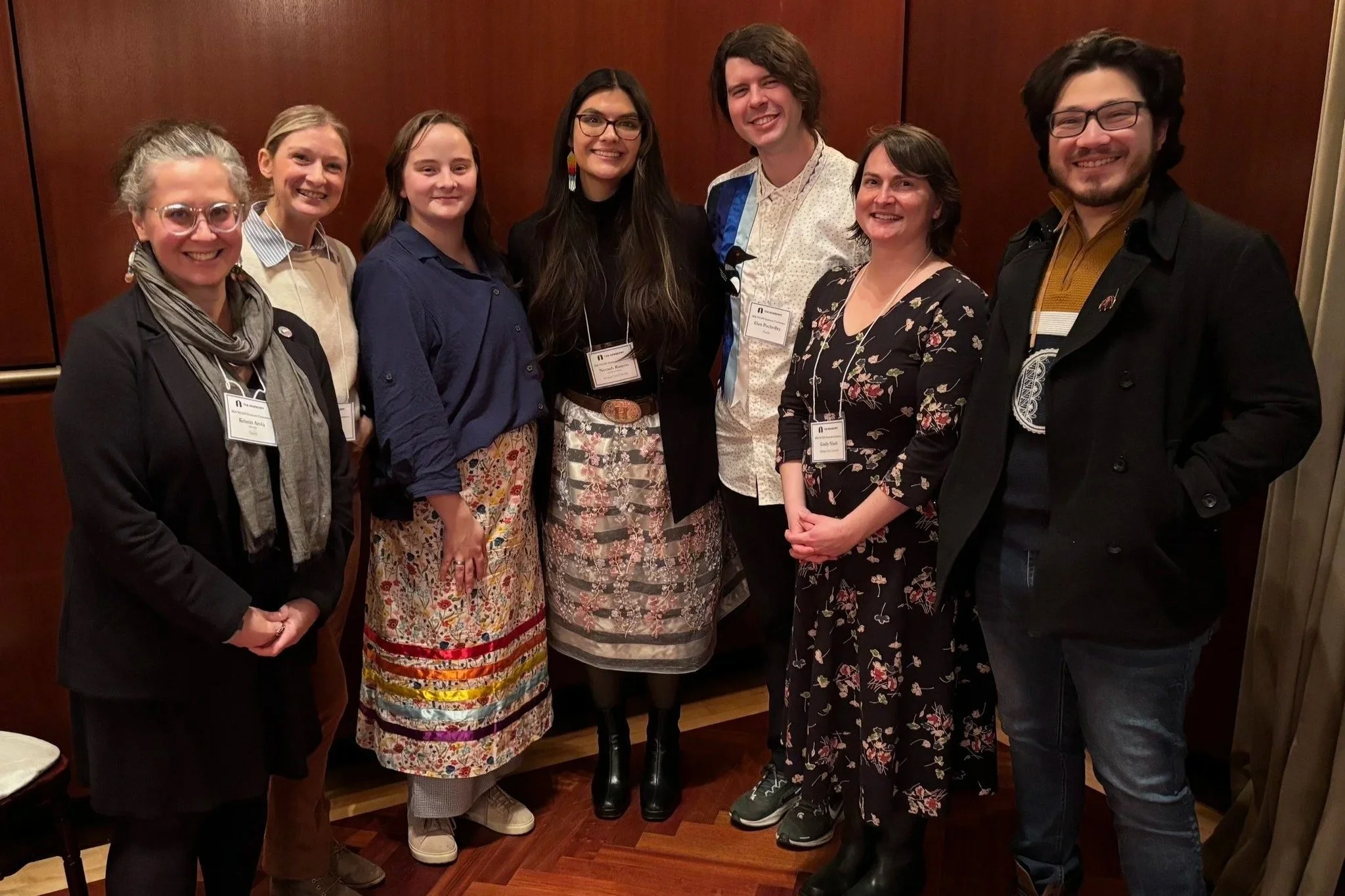 Seven individuals stand in a row posing for a photo at the Newberry Library in Chicago. Nevaeh Ramon placed in the middle, is surrounded by staff, faculty, and alumni of the Michigan State University American Indian and Indigenous Studies Program.