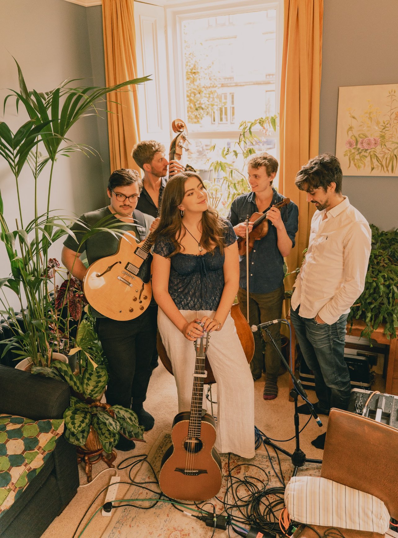 Niamh and her band in a tenement room with their instruments during a live session.