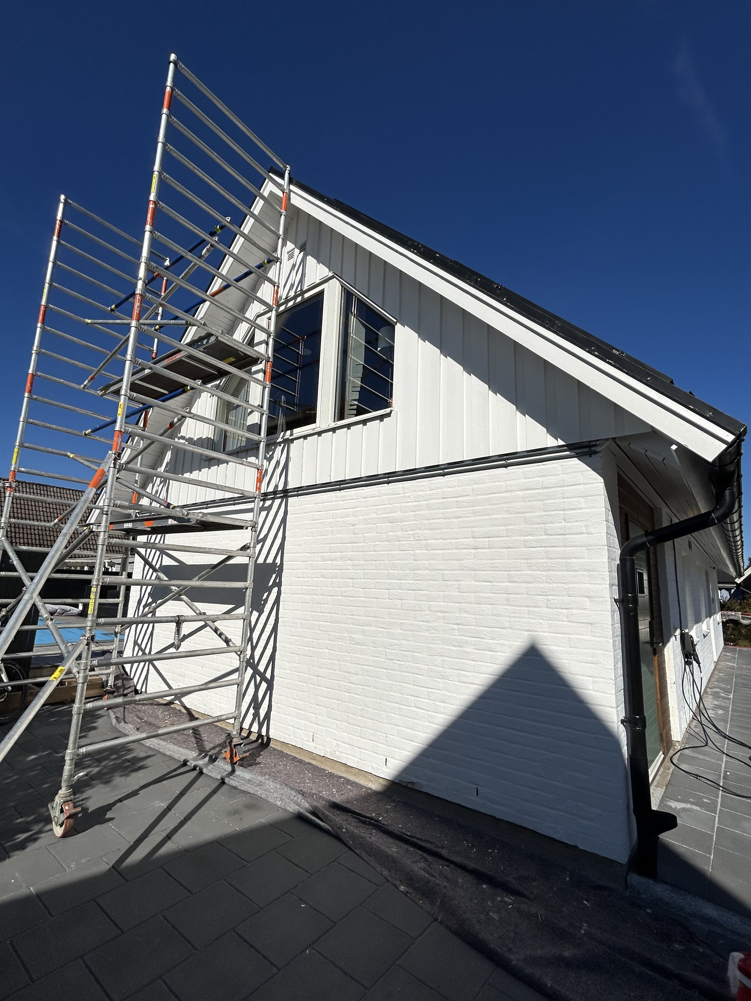 Fasadmålning av villa i Skåne med byggställning