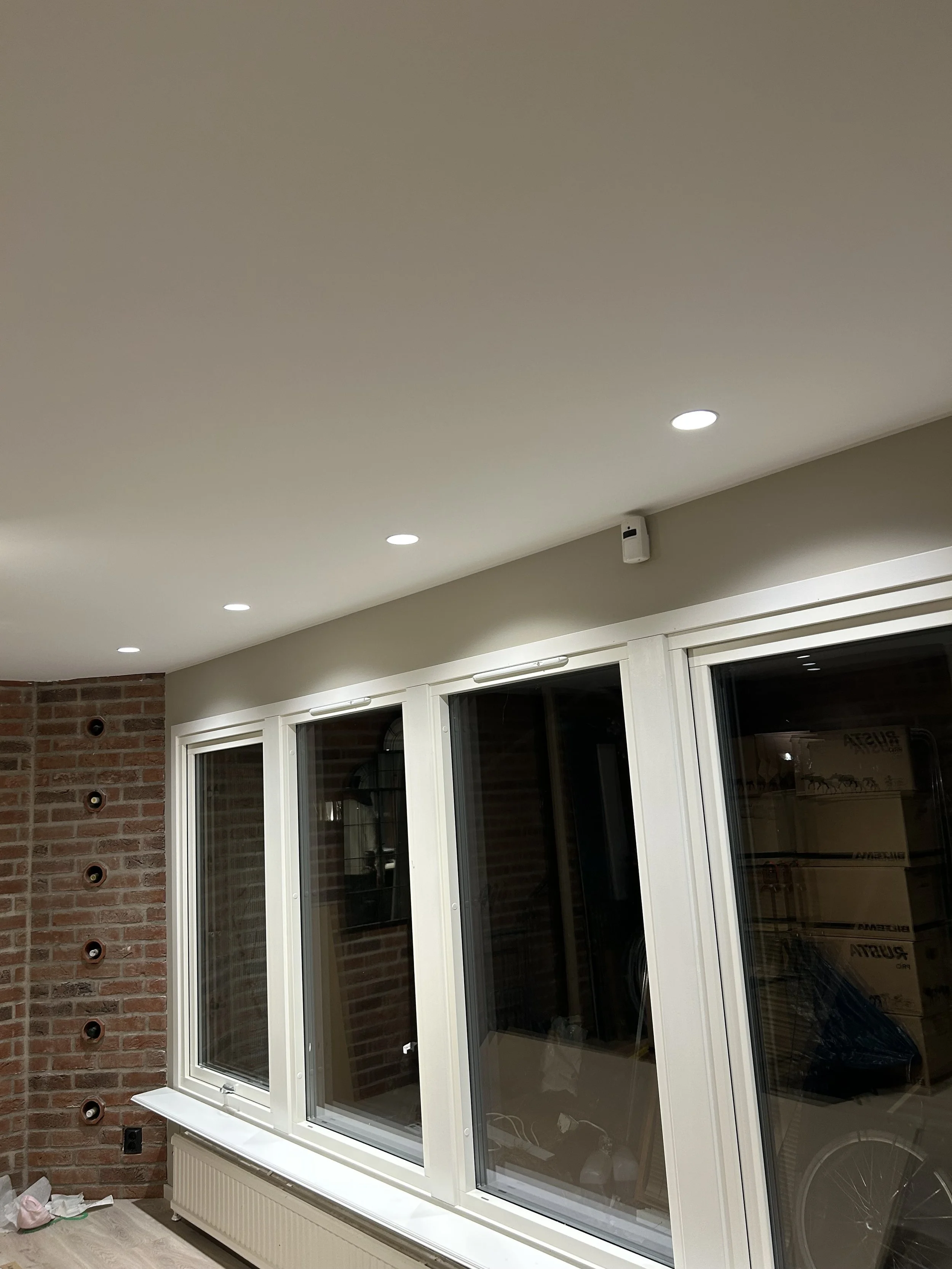 Nymålade väggar och tak i vardagsrum med spotlights