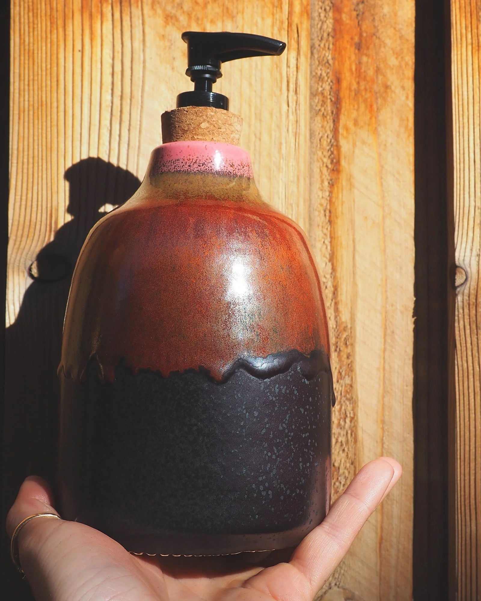 Ceramic soap dispenser resting in an open palm