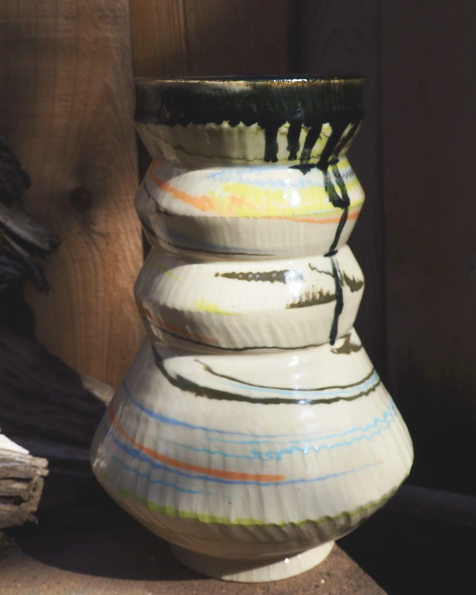 Side of the marbled clay vase showing the dark glaze drip