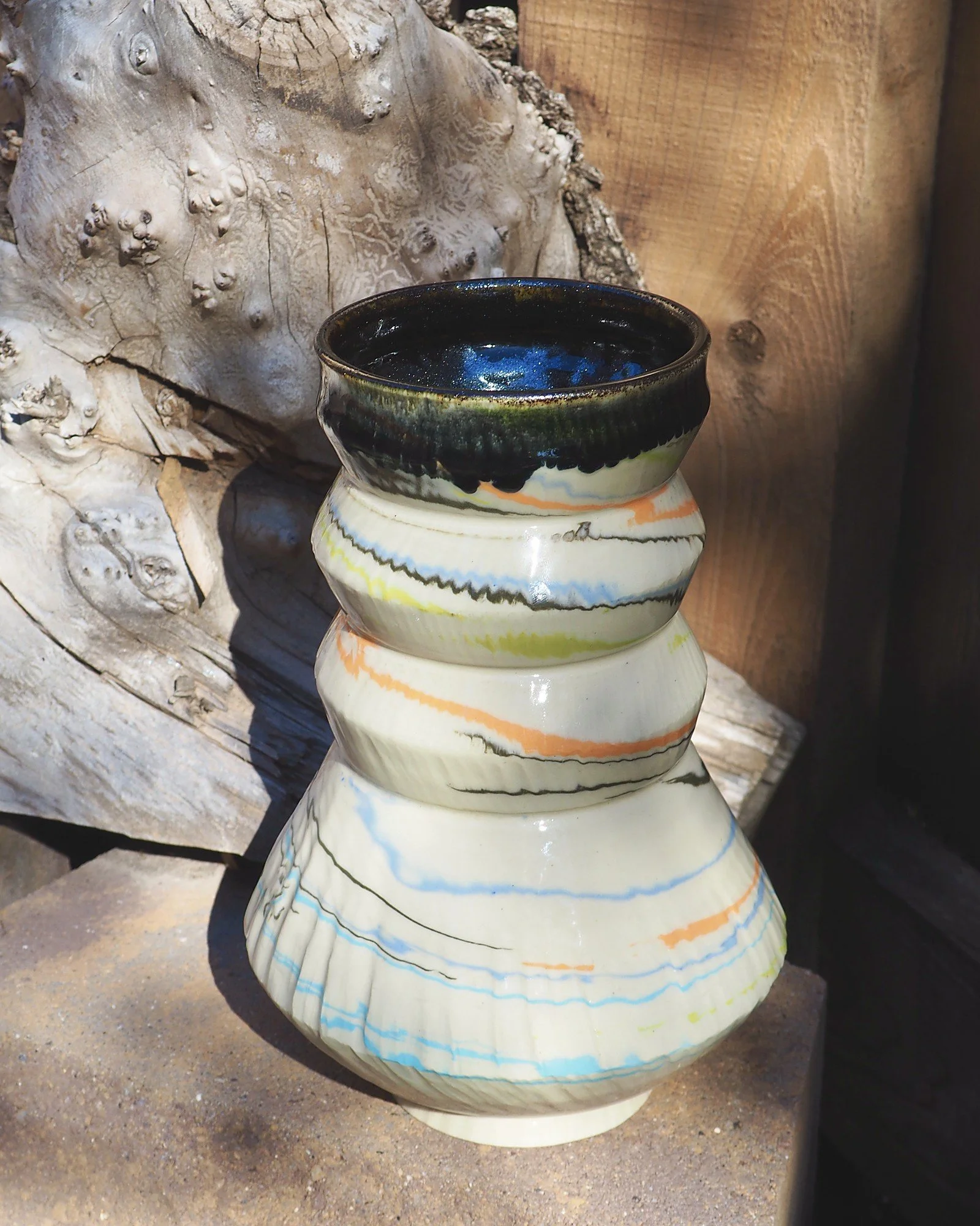 Marbled Swirl Tower, a handmade marbled clay vase with blue, orange and chartreuse swirls and a dark drip glaze rim