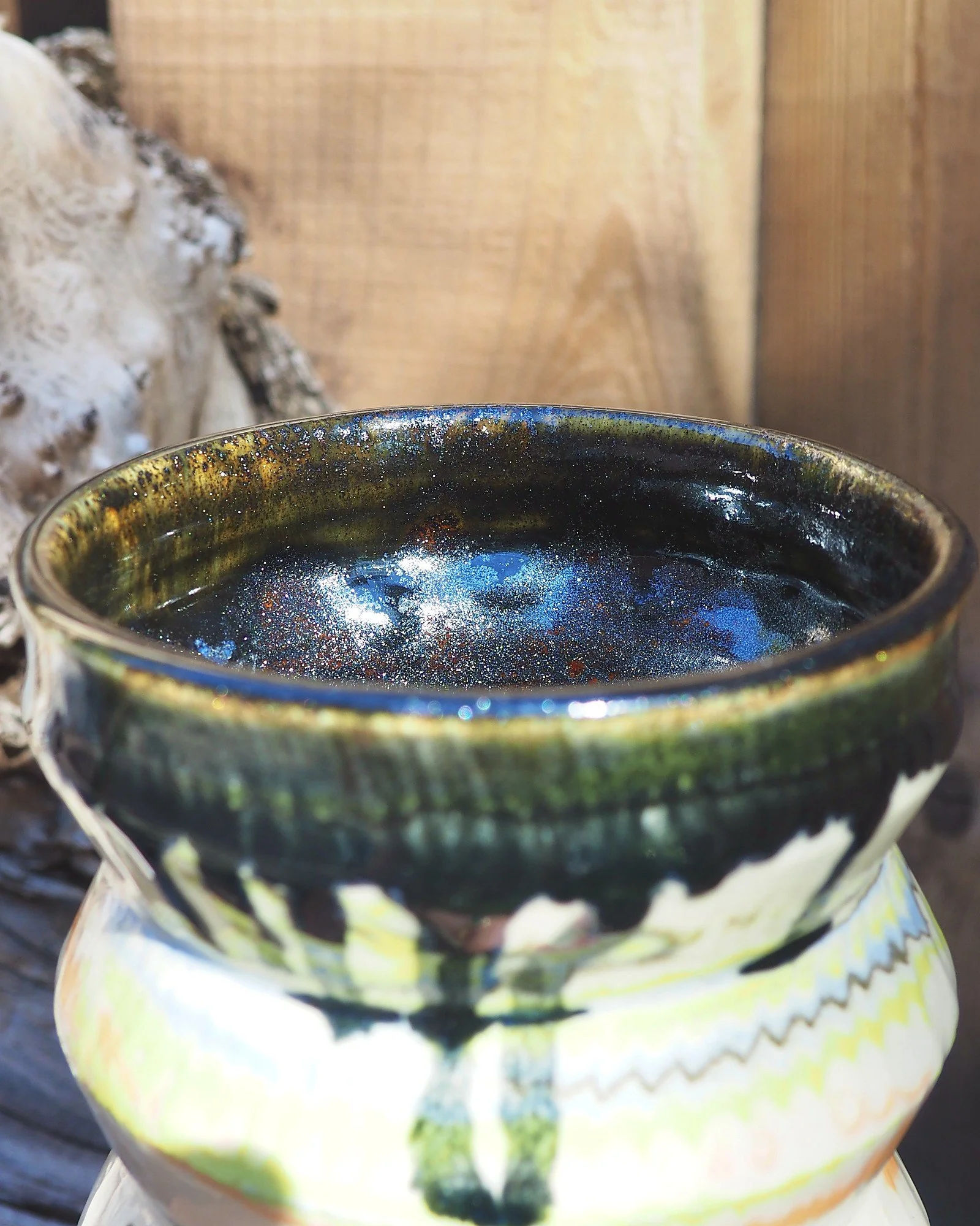 Close-up of the dark drip glaze rim on the marbled clay vase
