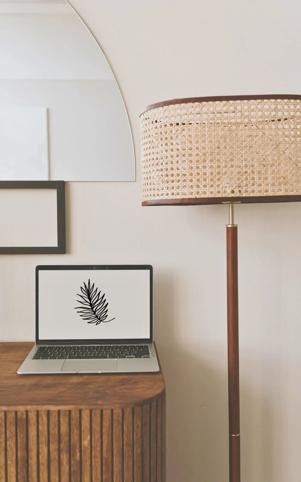 A laptop displayed on a wooden table, next to a floor lamp at the office of therapist Gail Gerbig at Seaside Mental Wellness located in Lakewood Ranch.