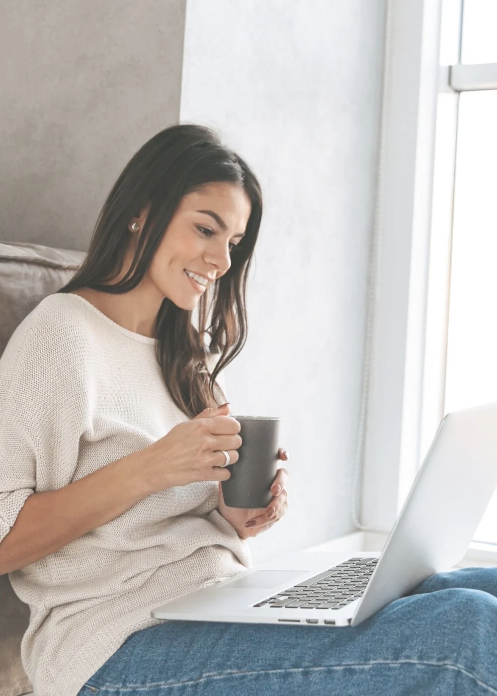 A woman with a laptop smiles as she talks with her therapist Gail Gerbig at Seaside Mental Wellness in Lakewood Ranch, FL and learns how to manage her anxiety, worry, and stress.