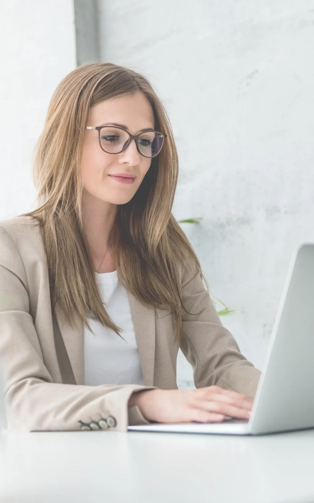A woman, in perimenopause, has her laptop at a desk and smiles as she finishes her counseling session with therapist Gail Gerbig at Seaside Mental Wellness in Lakewood Ranch, FL.