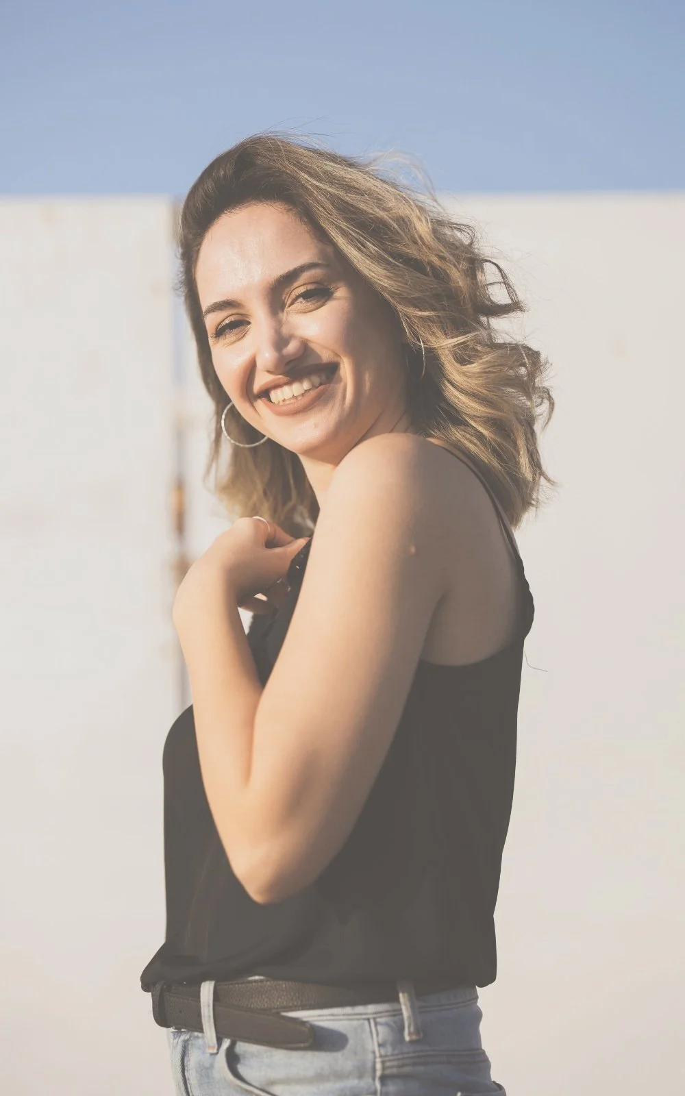 A woman smiles as she reflects on her session with therapist Gail Gerbig at Seaside Mental Wellness in Lakewood Ranch, FL which helped her cope with anxiety, emotional burnout, and manage stress.