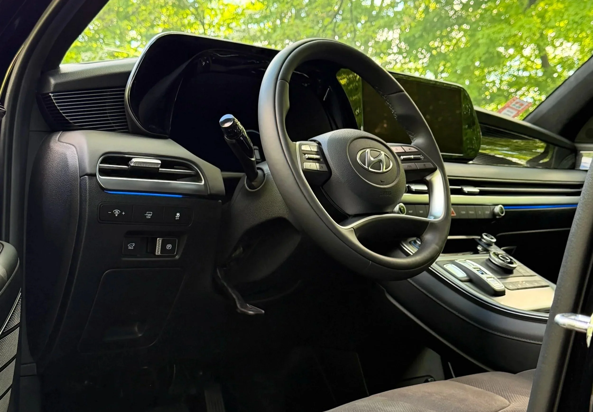 Interior of a modern Hyundai vehicle showing the steering wheel, dashboard, center console, and large touchscreen display.