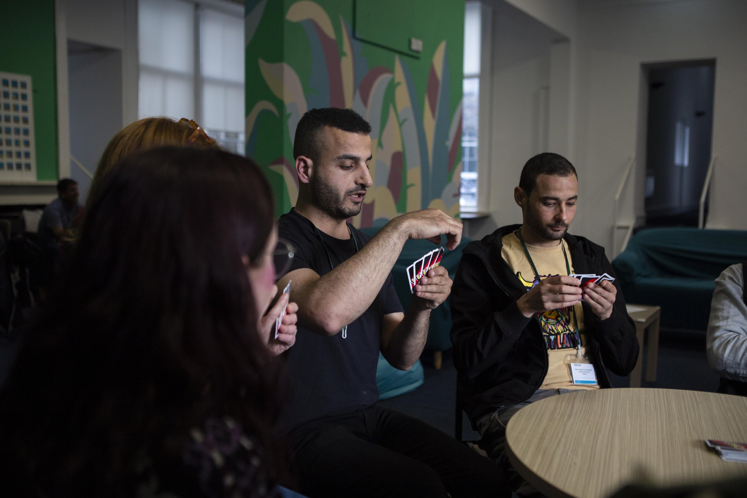 Classes are often informal, with language learning unfolding through conversation, humour, and the relationships formed between locals and newcomers. In this class they play the card game UNO together.