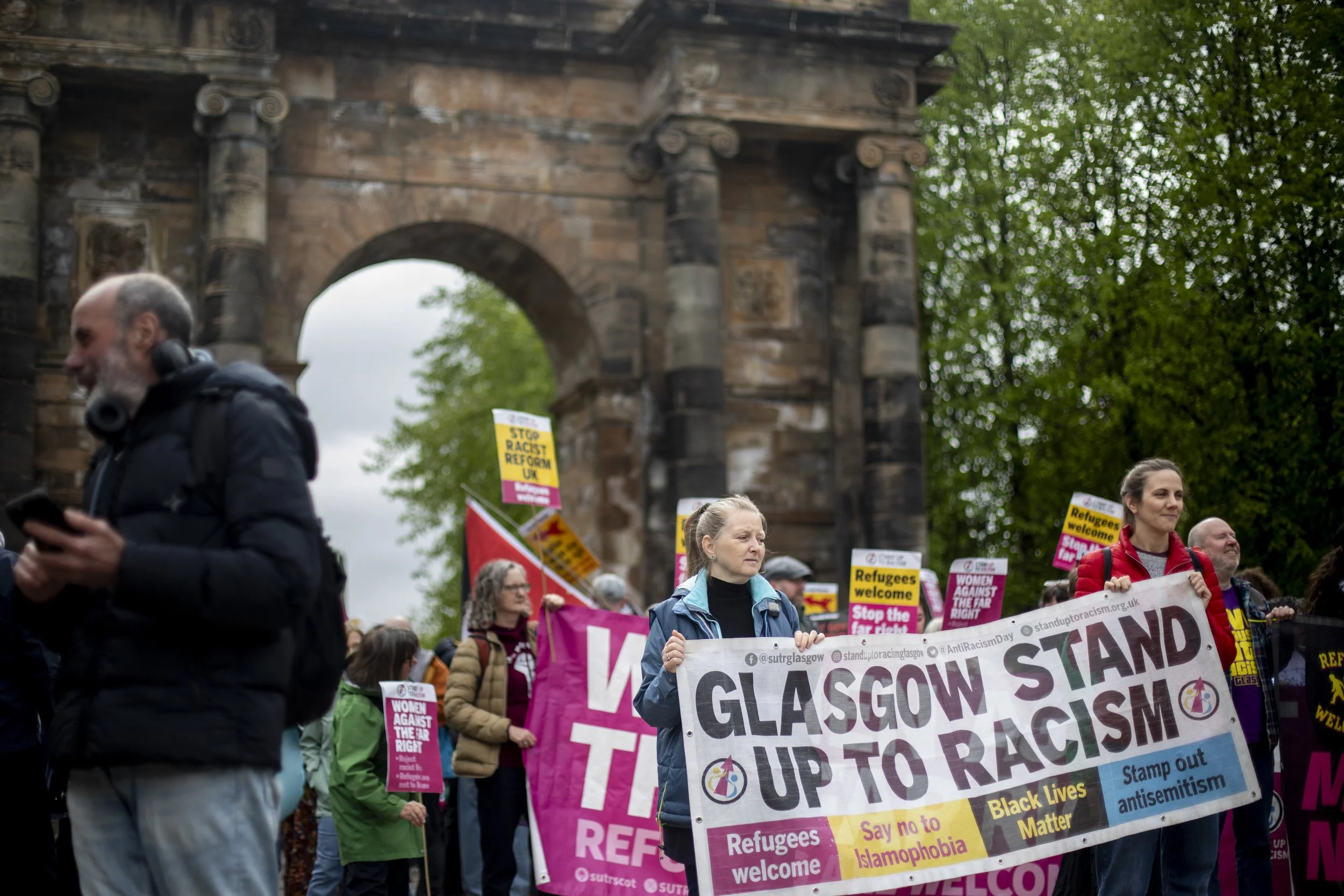 Anne (centre) carries the banner for the Glasgow Southside branch of Stand Up To Racism during the protest following the Scottish Parliament elections on 9 May 2026. A teacher, she joined the group last year after seeing far-right movements targeting