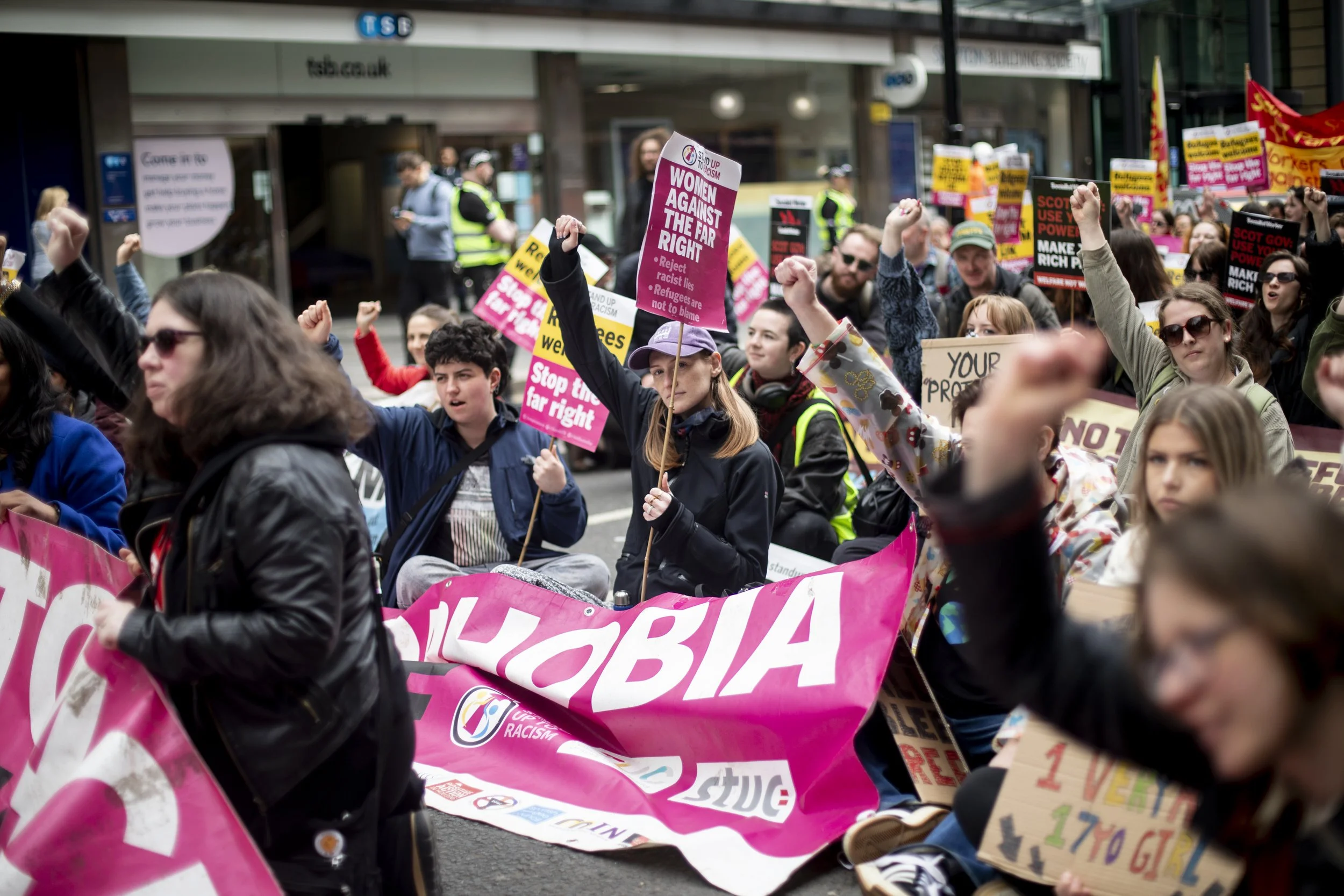 Activists sit on the street during a “day of rage against Reform” organised by Stand Up To Racism in Glasgow on 9 May 2026, following the Scottish Parliament elections.