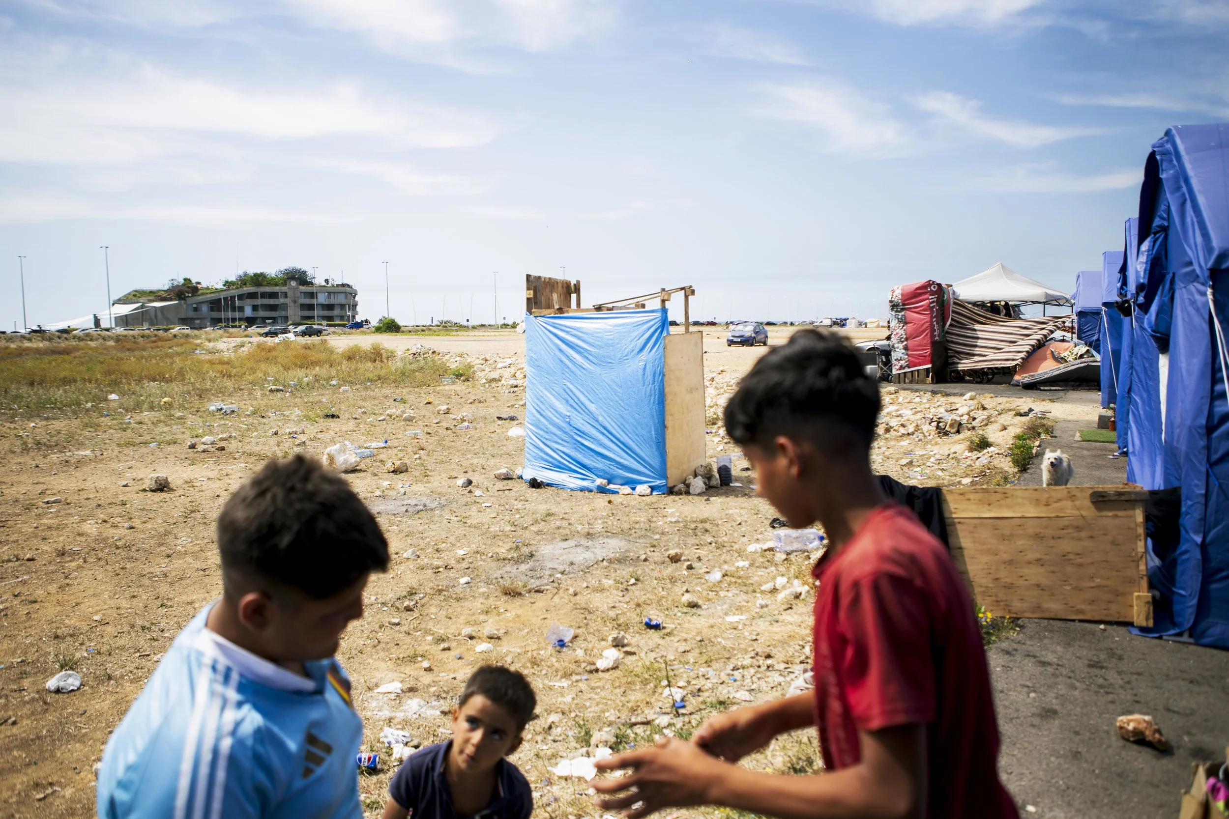 A makeshift camp, there is no water, electricity or plumbing in the camp. Residents came together to create an outside shower and toilet. 