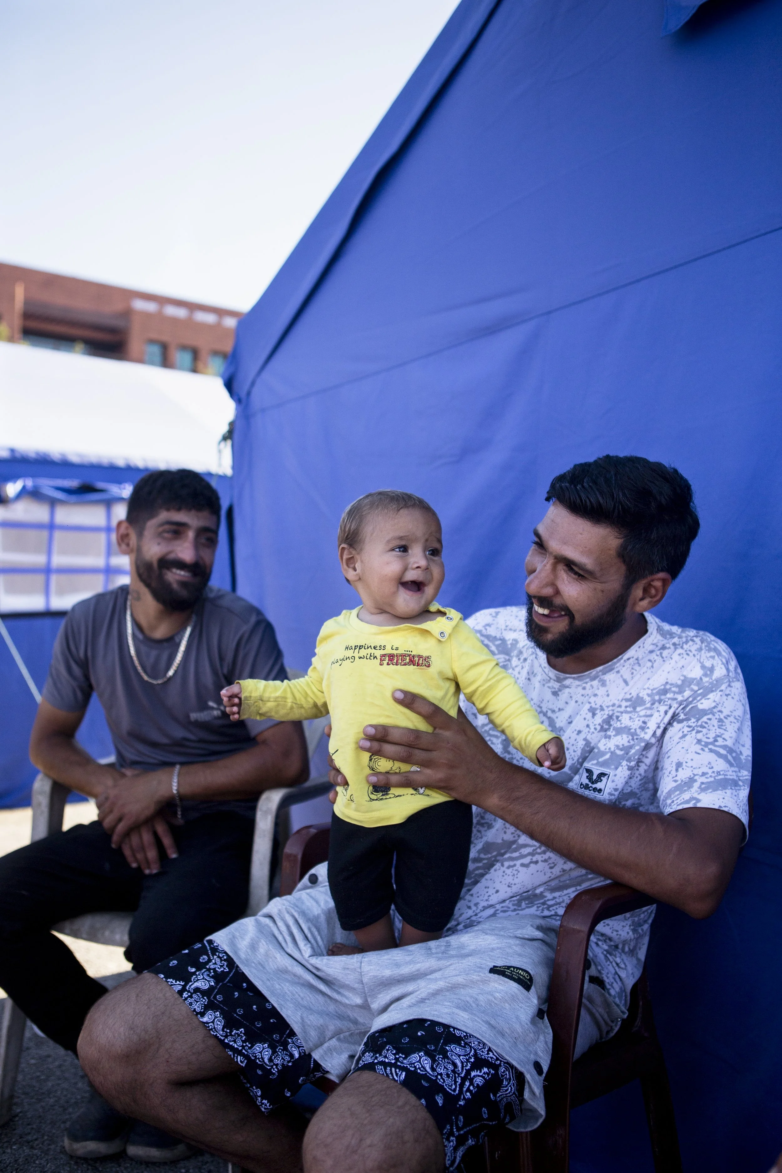 A father plays with his daughter in an IDP camp in Biel.