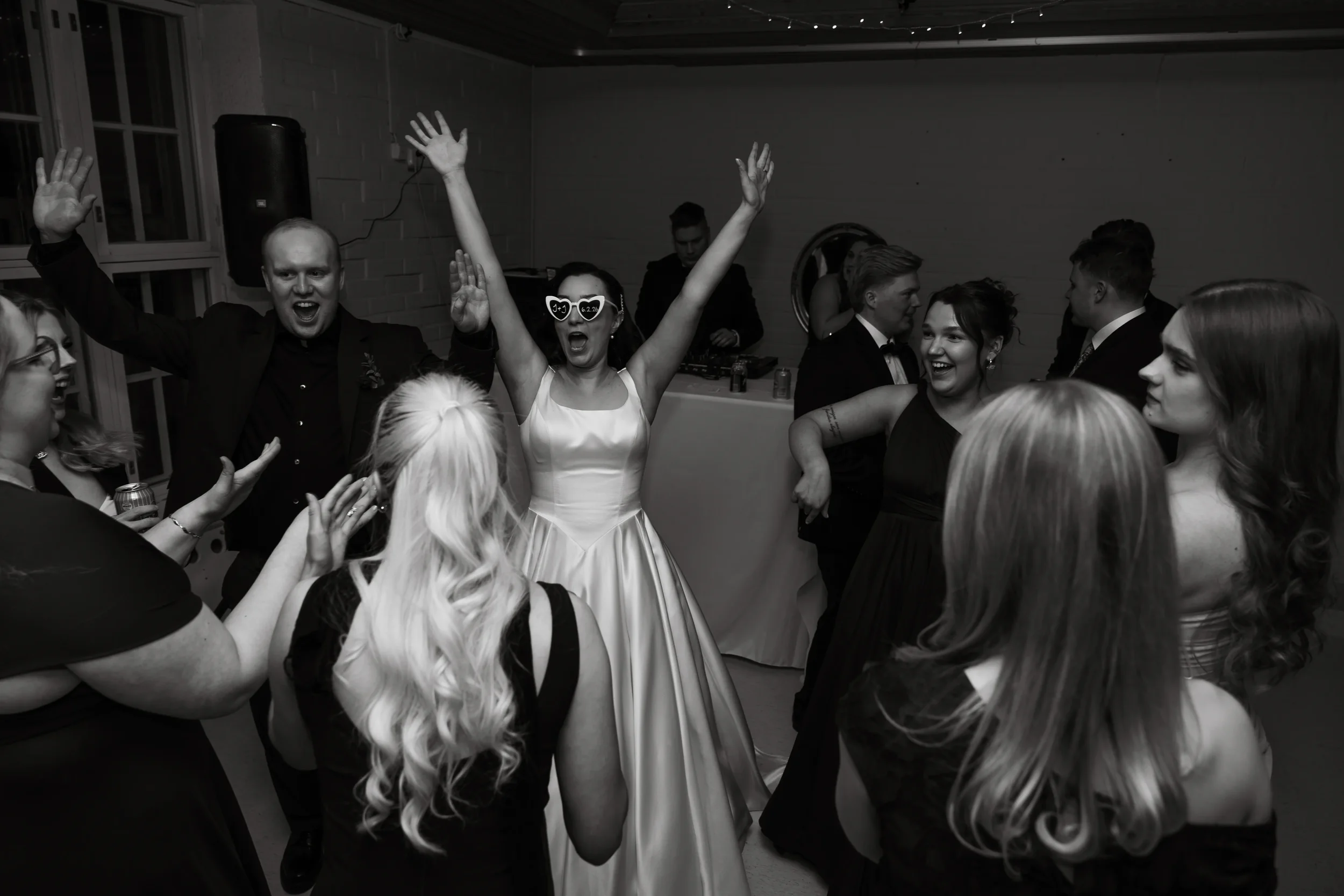 Morsiamen ja vieraiden tanssimista ja laulamista hääjuhlissa, valkoinen mekko ja iloiset ilmeet. Hääkuvaus Tampere.