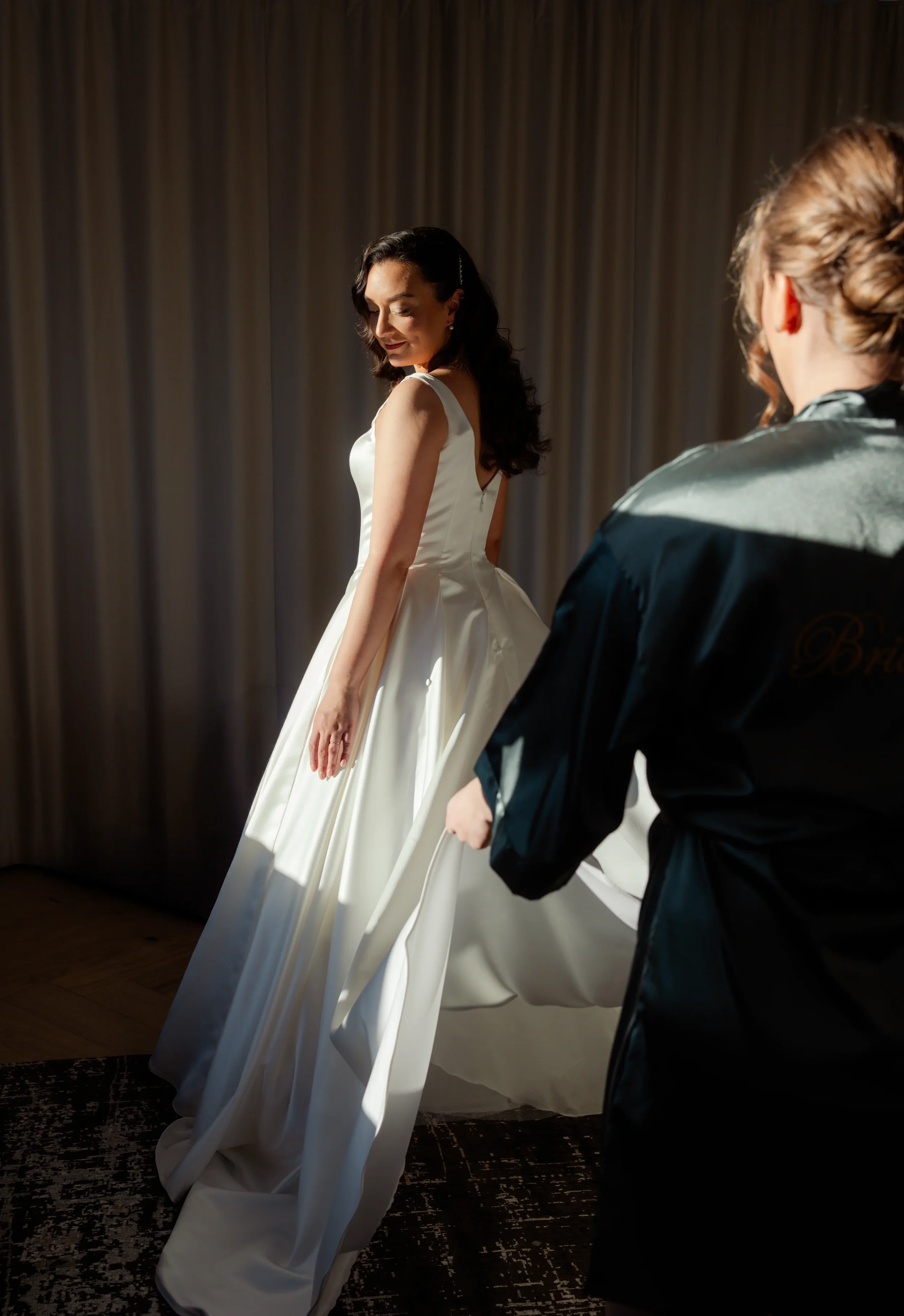 Morsian pukeutuneena häämekkoon ja kaaso korjaa mekon alla vannehametta. Hääkuvaaja Tampere.