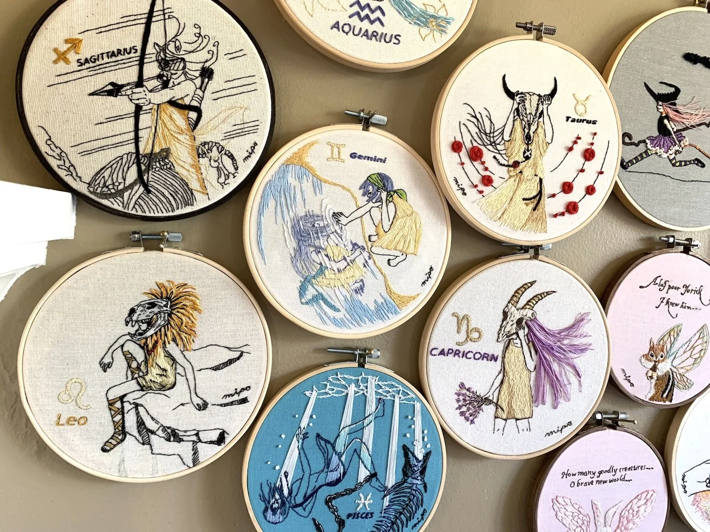 Finished zodiac embroidery series on a wall .jpeg