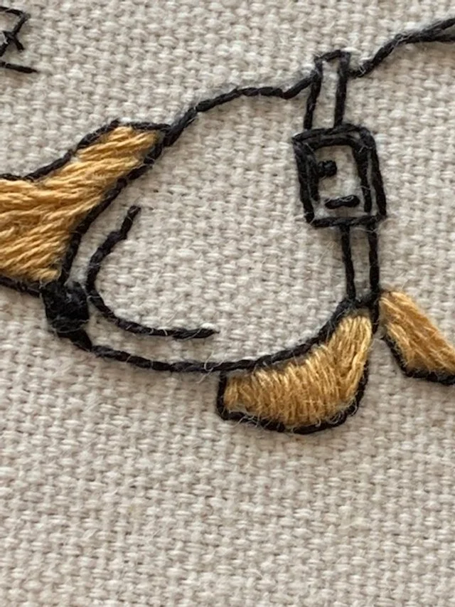 close up to a upside down beagle embroidery design.jpg