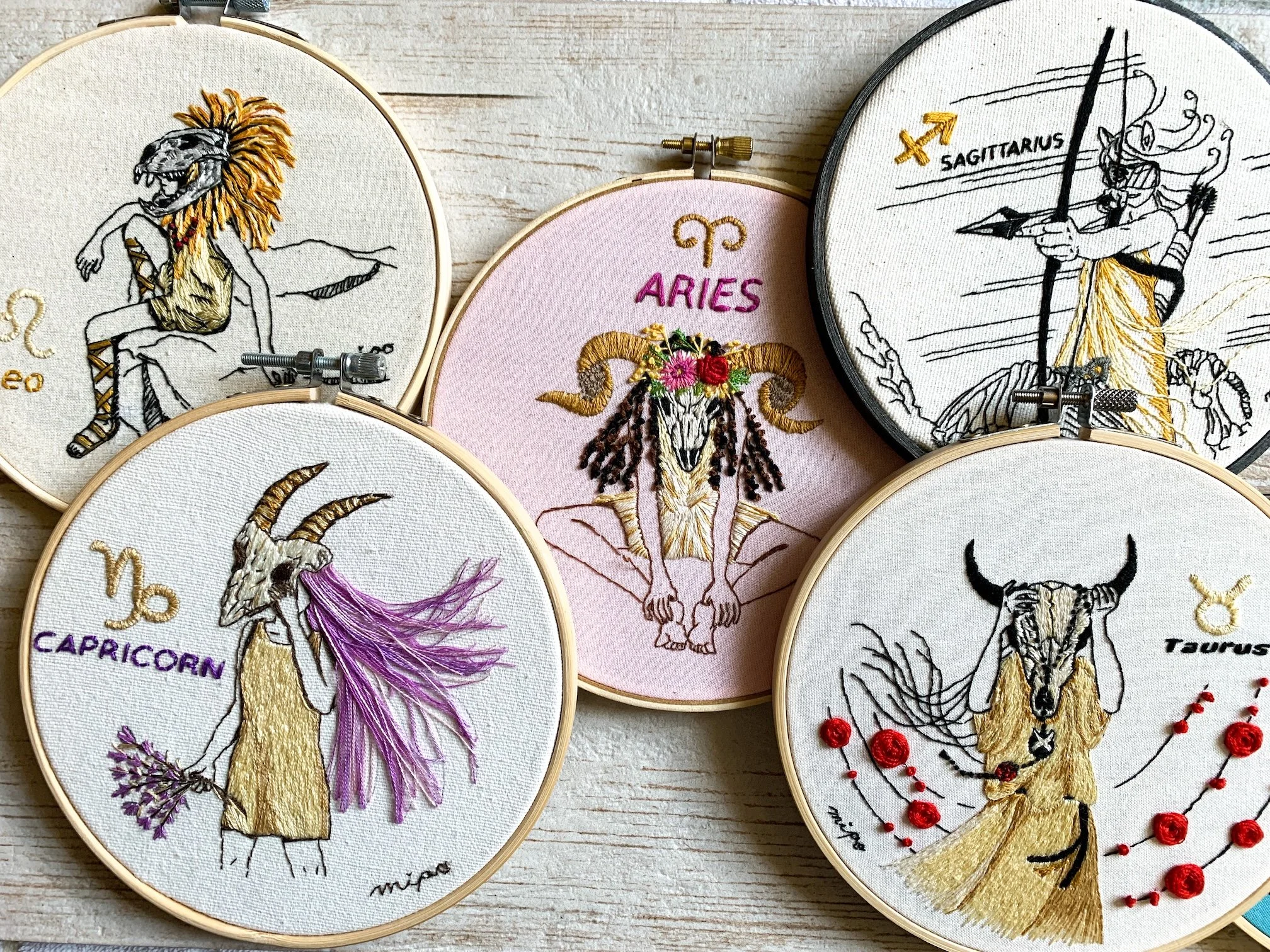 Finished Taurus zodiac embroidery hoop art with bull skull girl and red rose motif on embroidery wall.jpeg