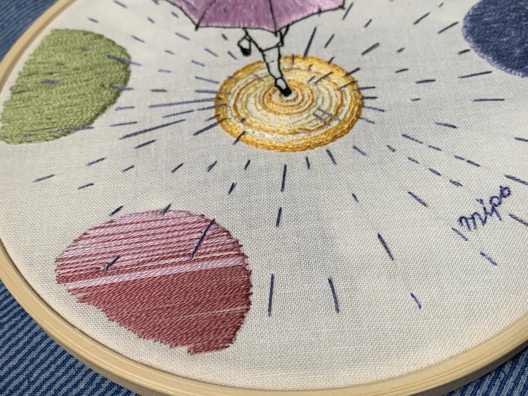 Rainy day embroidery with colorful puddles and radial rain stitches.jpeg