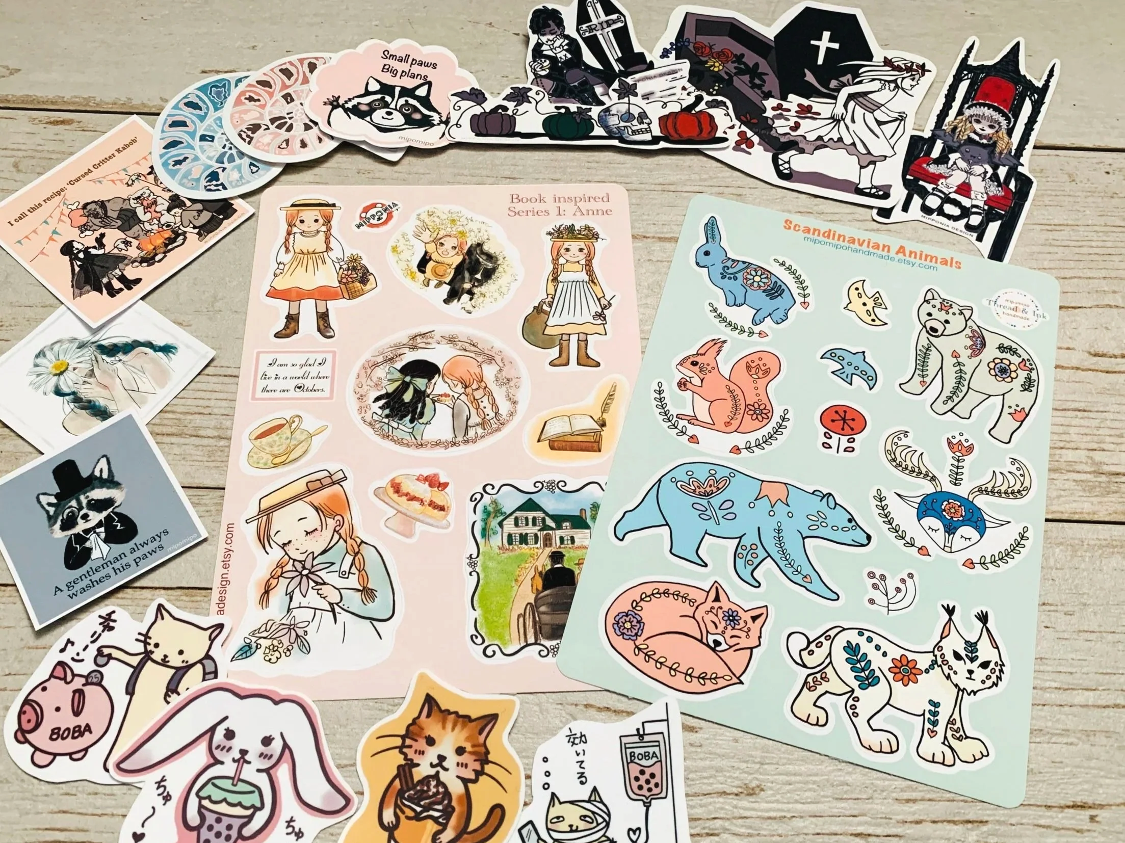 A collection of decorative stickers and paper items featuring animals, fairy-tale characters, and whimsical designs, arranged on a light wooden surface.