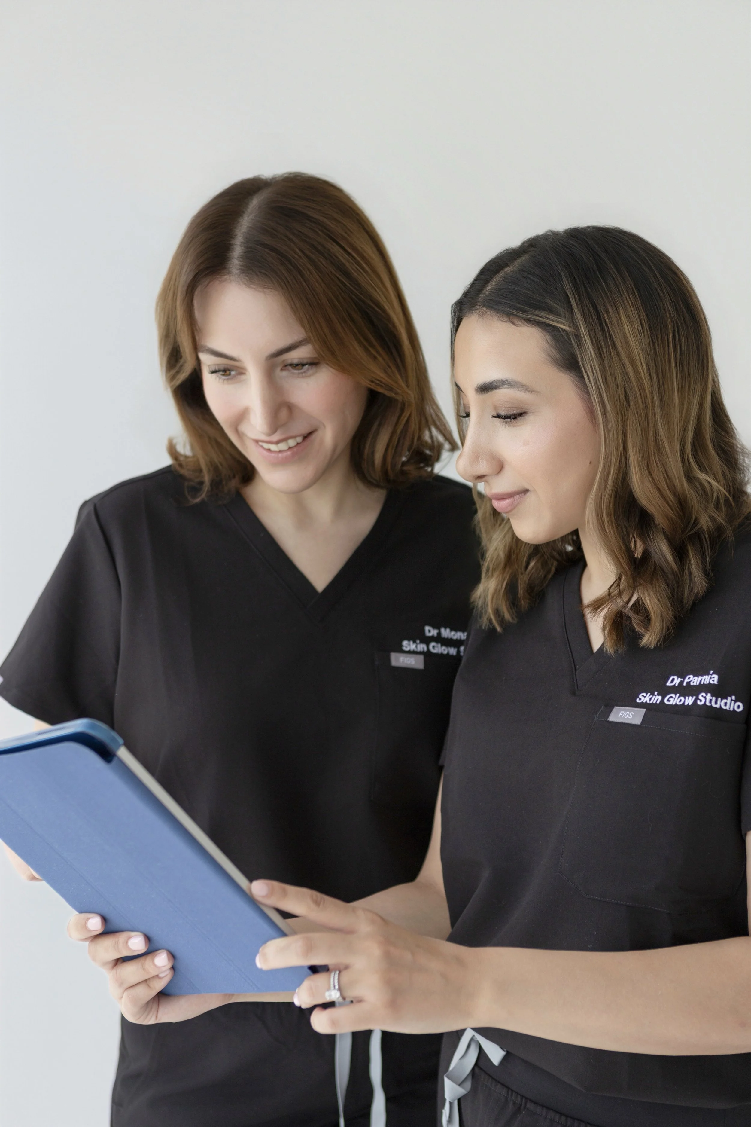Co-founders Dr. Mona and Dr. Parnia reviewing aesthetic treatments at Skin Glow Studio in Beaconsfield