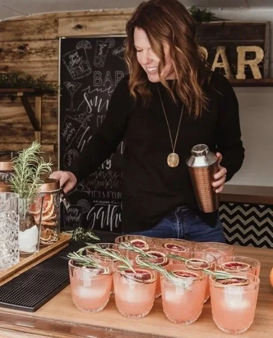 Woman bartender mixing beautiful cocktails behind the bar at a special event