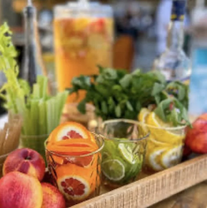 Fresh, seasonal ingredients and garnishes on a mobile event bar. Fresh citrus and herbs ready to go for a garden to glass cocktail or mocktail.