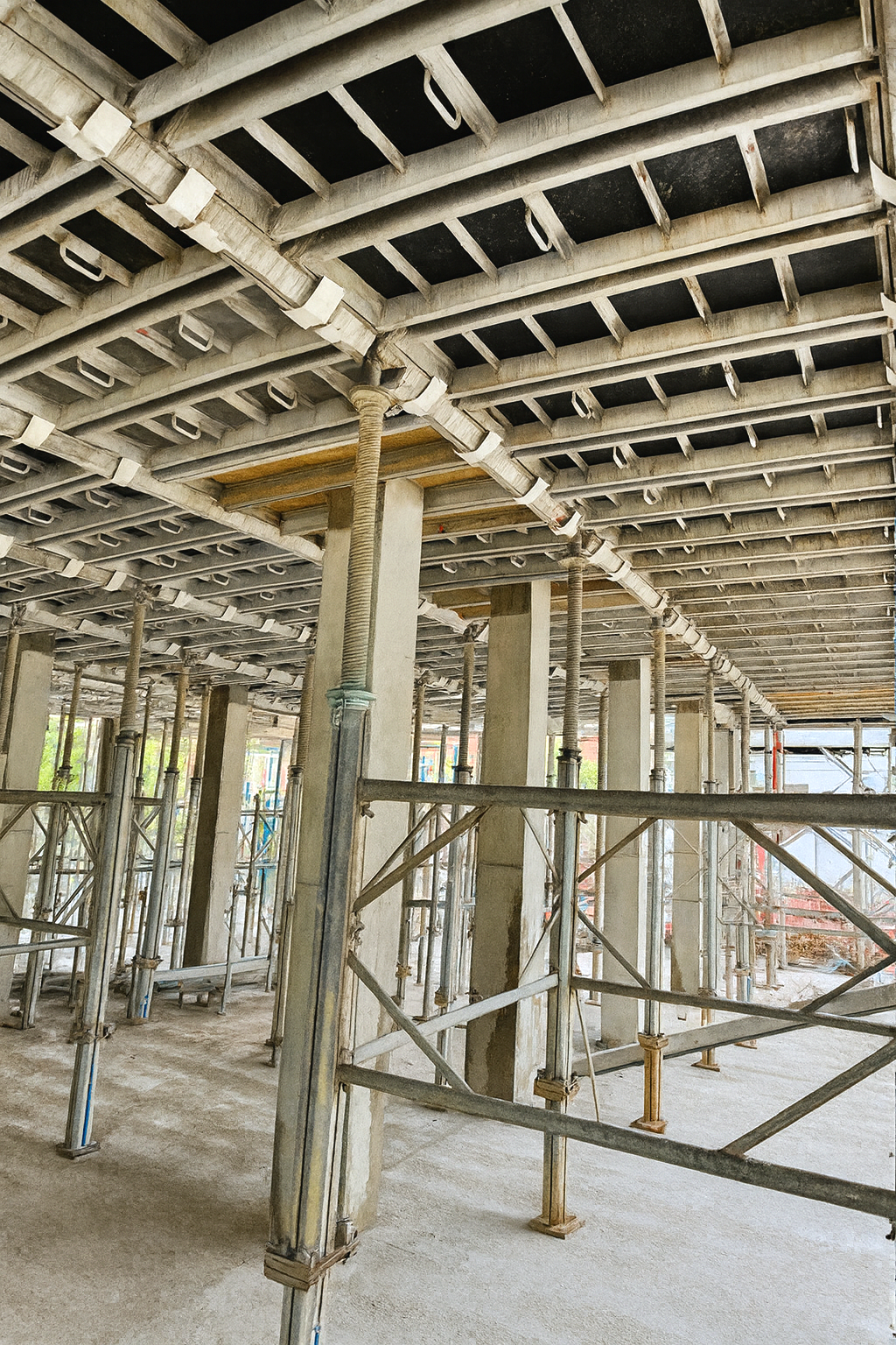 Construction site with scaffolding and support beams for building foundation.